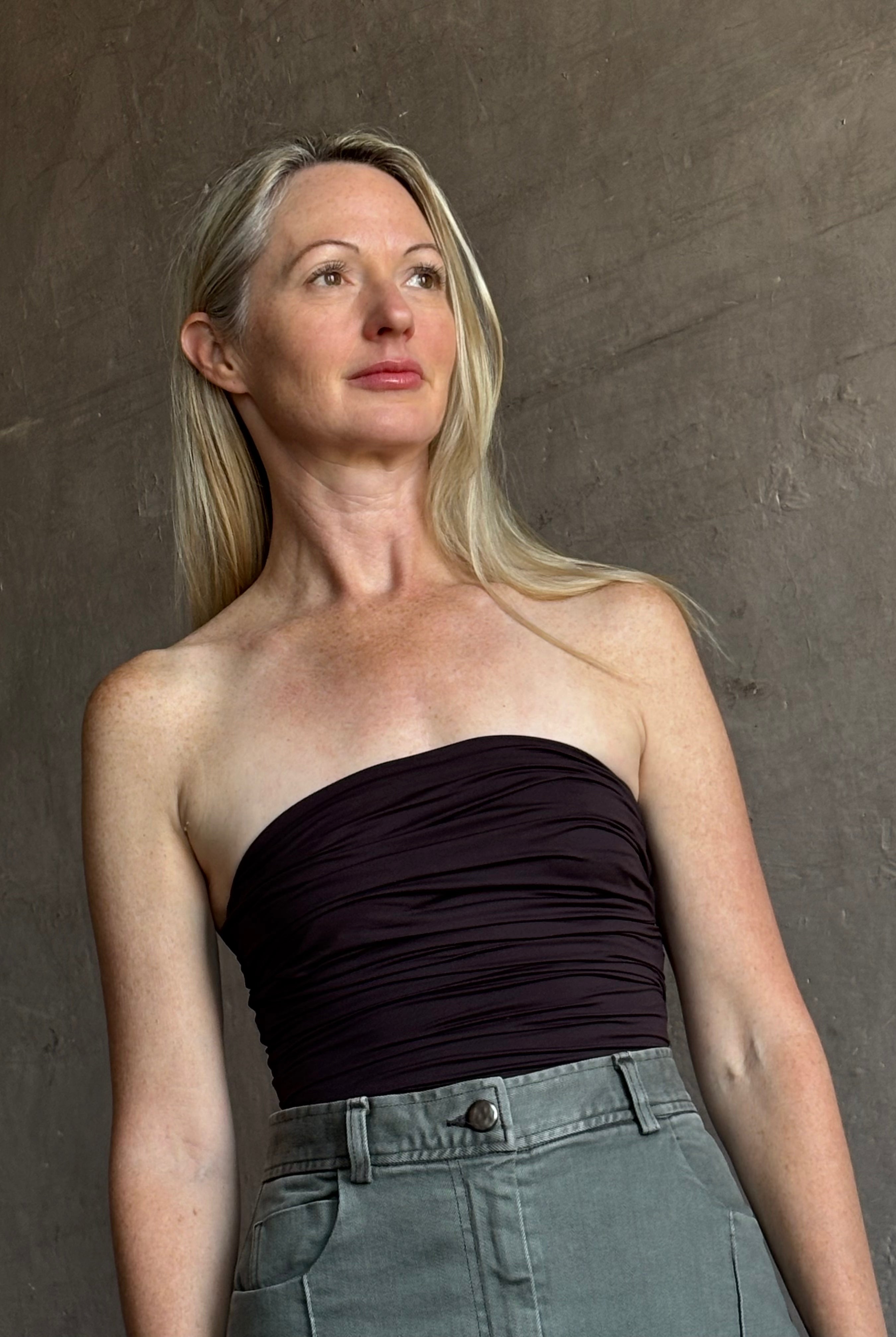 Image of mature woman wearing AGOLDE Gwyneth Bodysuit in chocolate brown with premium stretch for timeless versatile styling