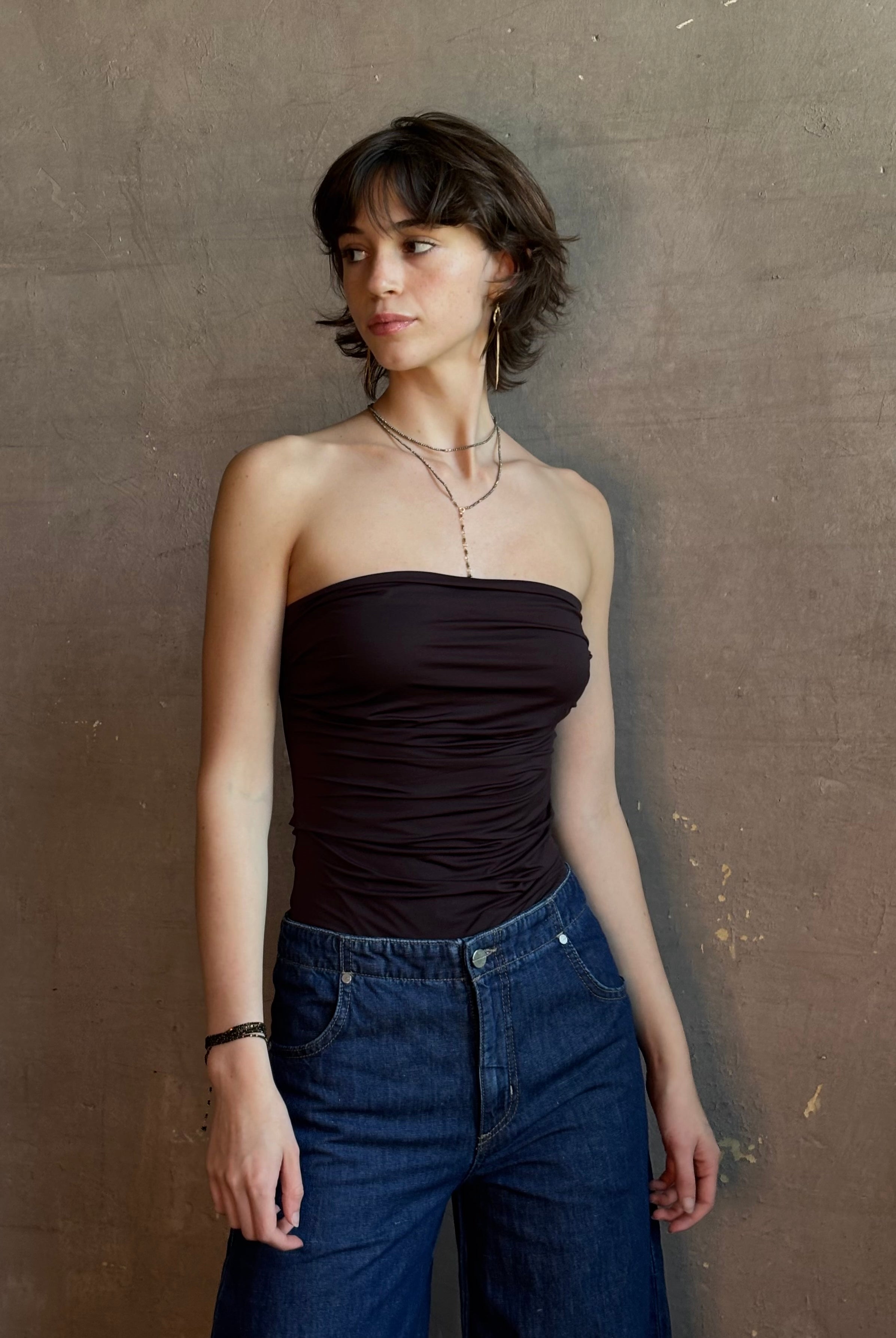 Woman wearing AGOLDE Gwyneth Bodysuit in chocolate brown with premium stretch for timeless versatile styling with gathered fabric body that is very forgiving while form fitted