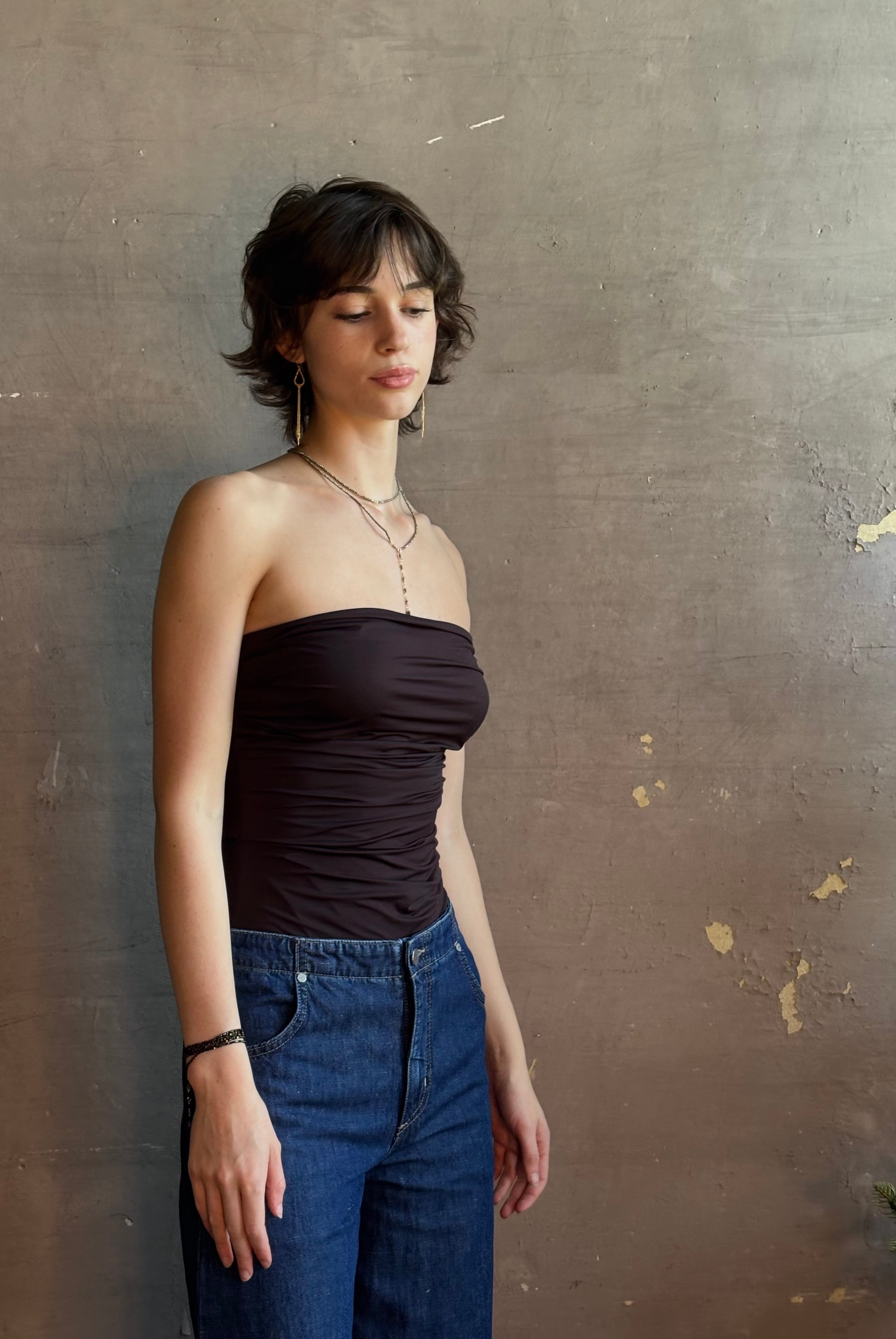 Woman wearing AGOLDE Gwyneth Bodysuit in chocolate brown with premium stretch for timeless versatile styling with gathered fabric body that is very forgiving while form fitted