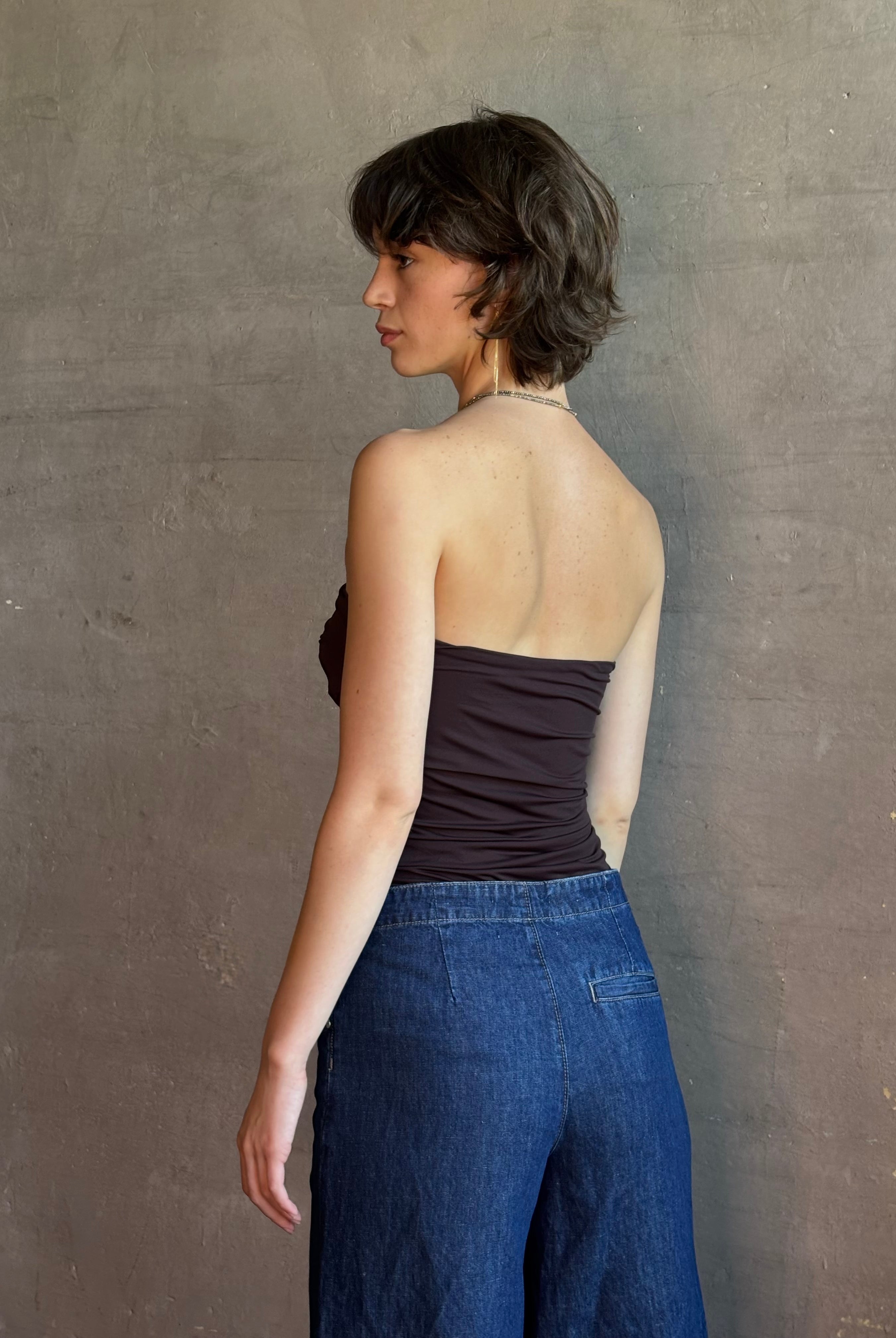 Woman wearing AGOLDE Gwyneth Bodysuit in chocolate brown with premium stretch for timeless versatile styling with gathered fabric body that is very forgiving while form fitted