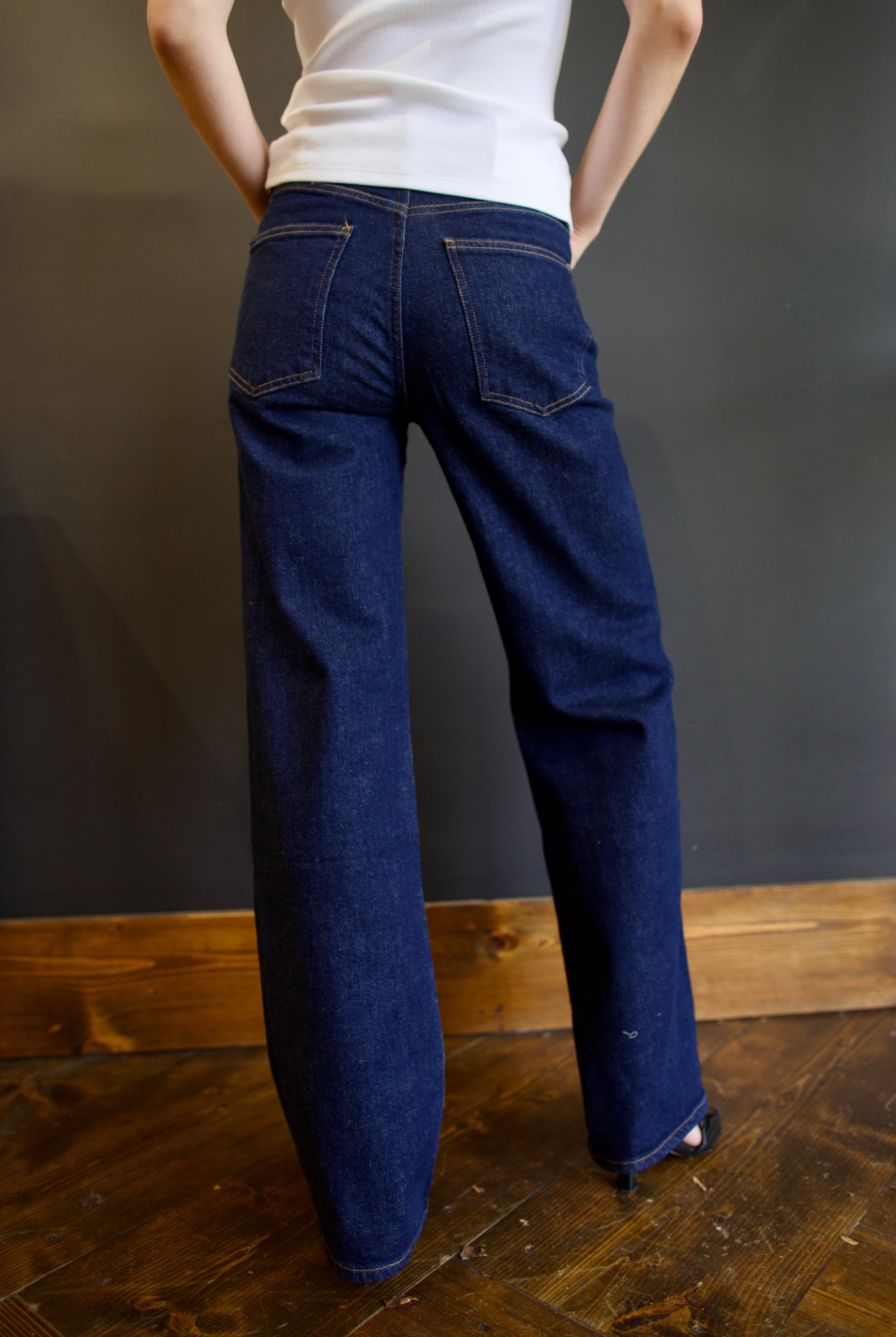 Model wearing Agolde harper denim in reissue wash that is not distressed, full length with a finished hem that can easily be dressed up or down