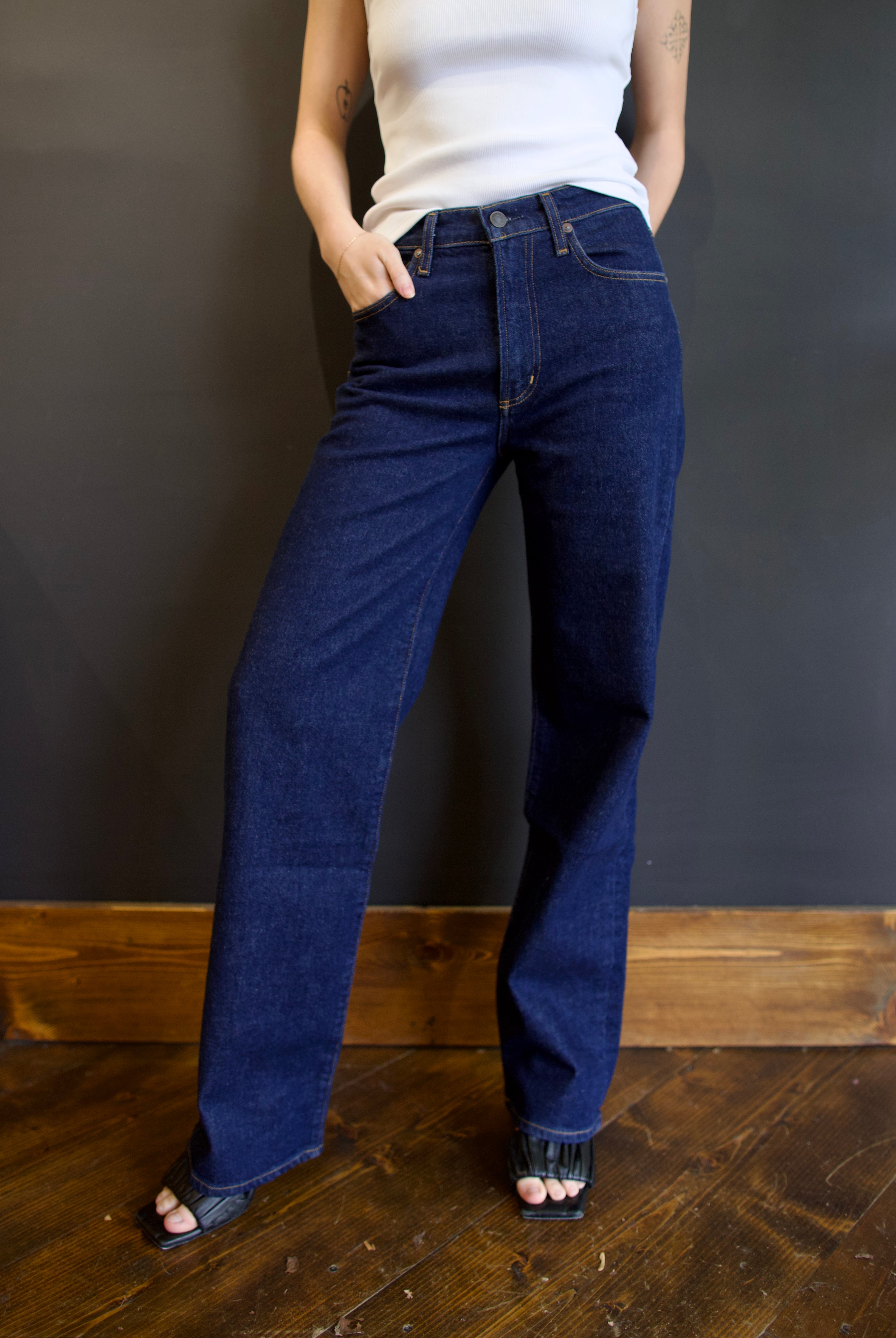 Model wearing Agolde harper denim in reissue wash that is not distressed, full length with a finished hem that can easily be dressed up or down