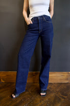 Model wearing Agolde harper denim in reissue wash that is not distressed, full length with a finished hem that can easily be dressed up or down