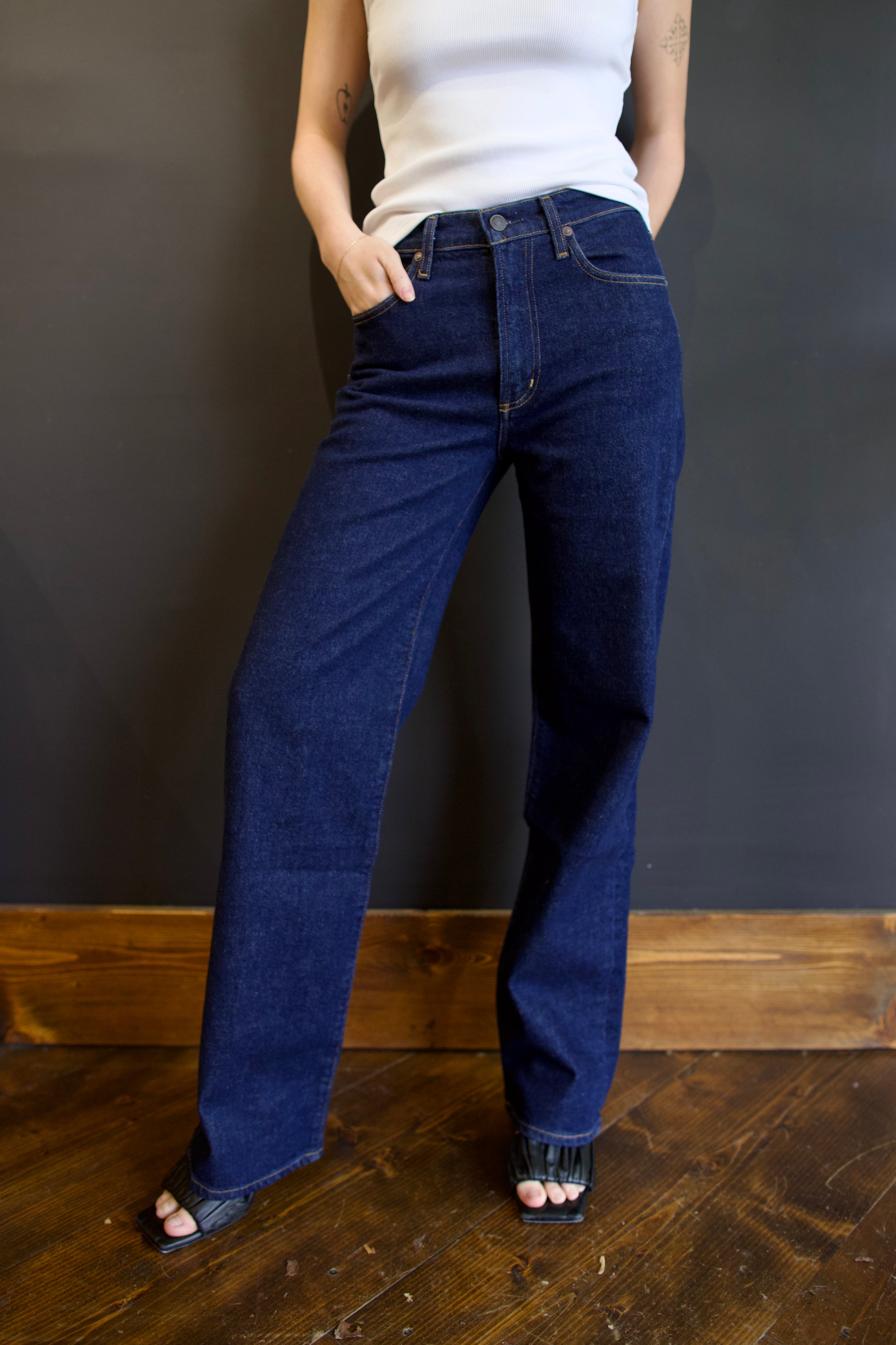 Model wearing Agolde harper denim in reissue wash that is not distressed, full length with a finished hem that can easily be dressed up or down