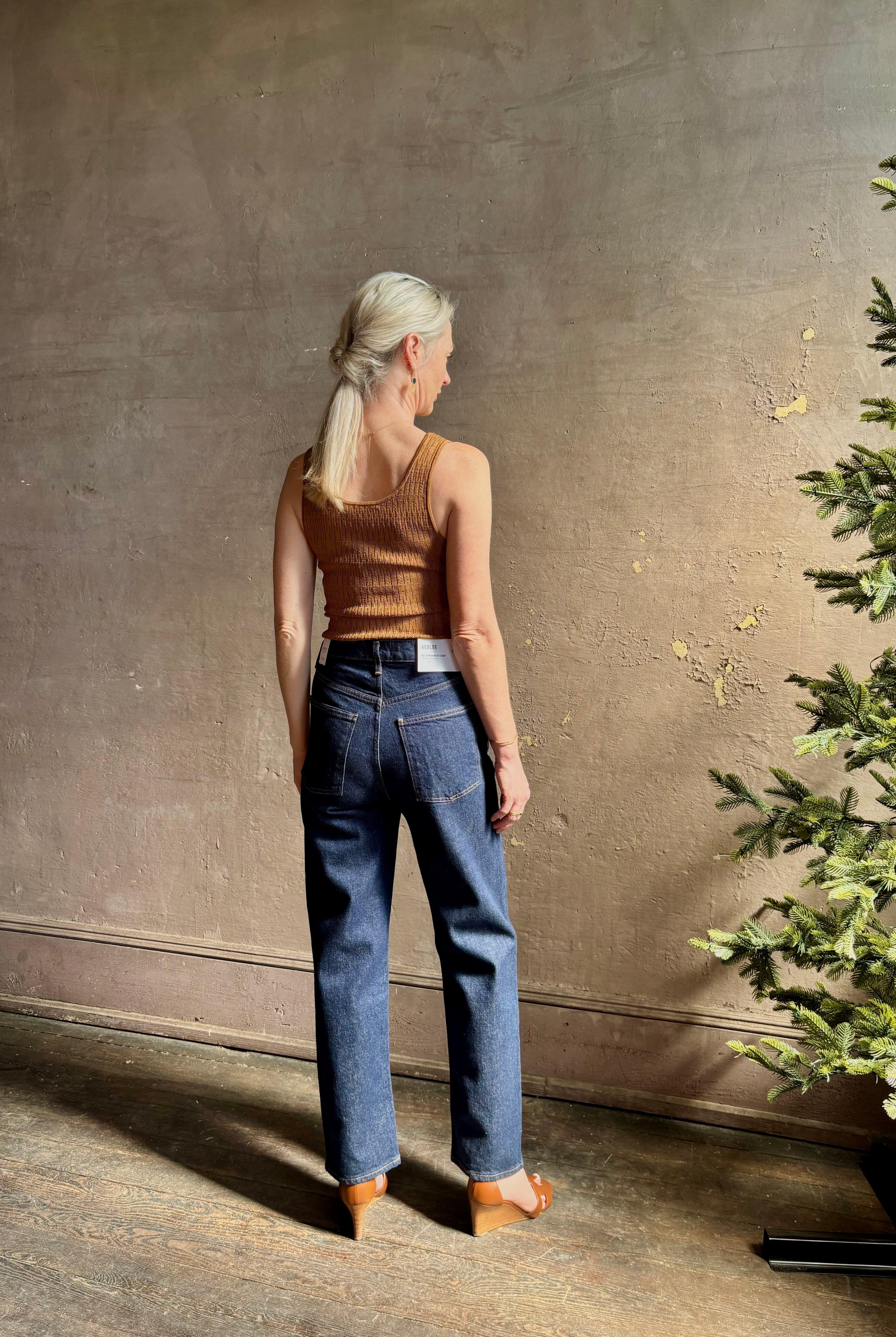 Mature woman wearing Agolde 90's Pinch Waist Crop with regenerative cotton zip closuredark wash