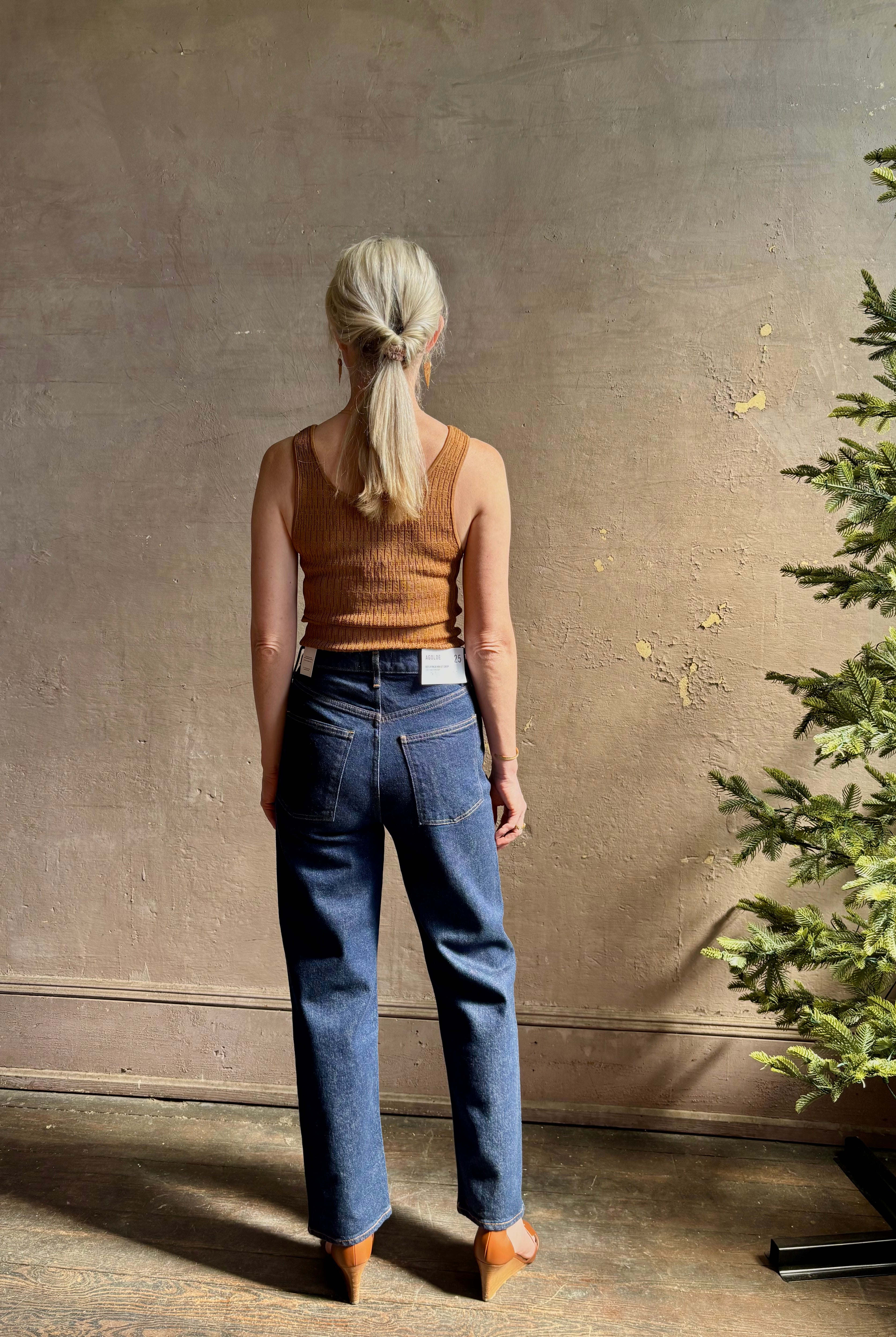 Mature woman wearing Agolde 90's Pinch Waist Crop with regenerative cotton zip closure back pockets