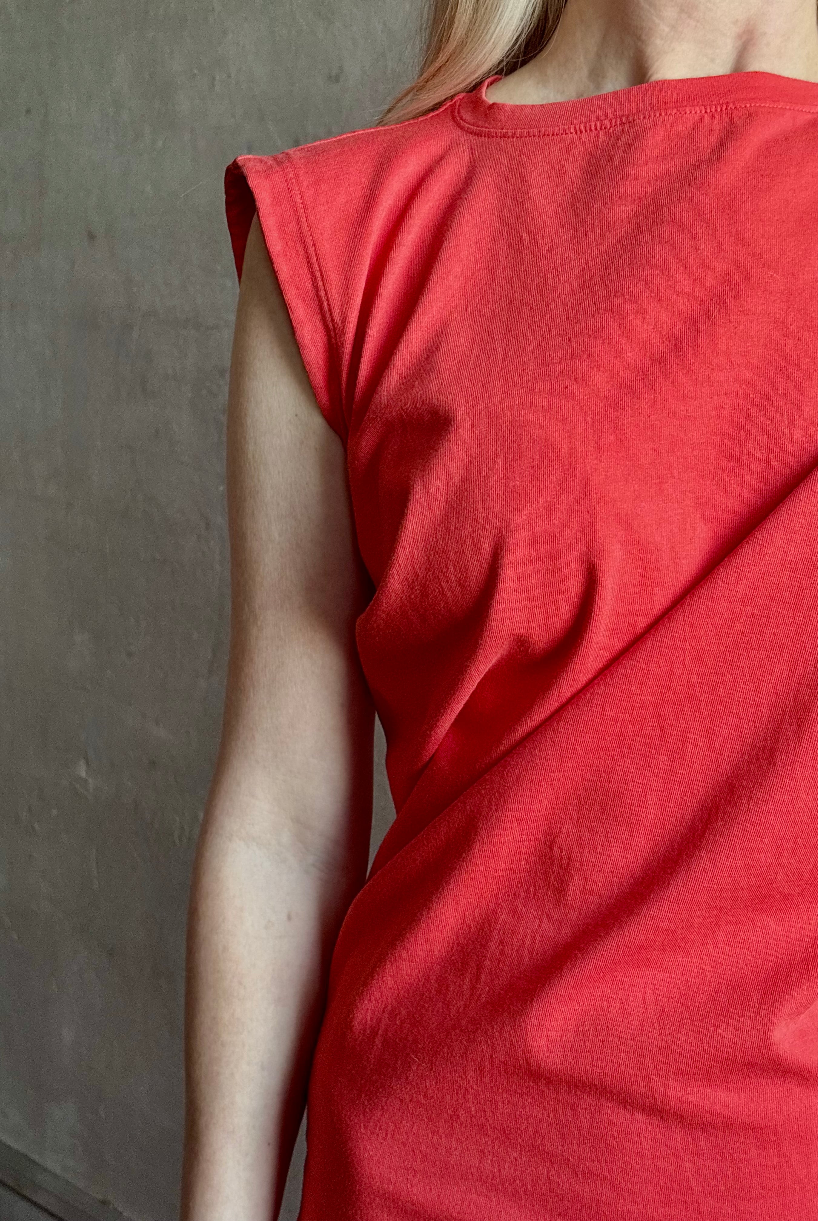 Woman wearing the red Beth Dress from Agolde crafted from 100% cotton with short sleeves, knee length and asymmetrical twist draping in a effortless relaxed fit