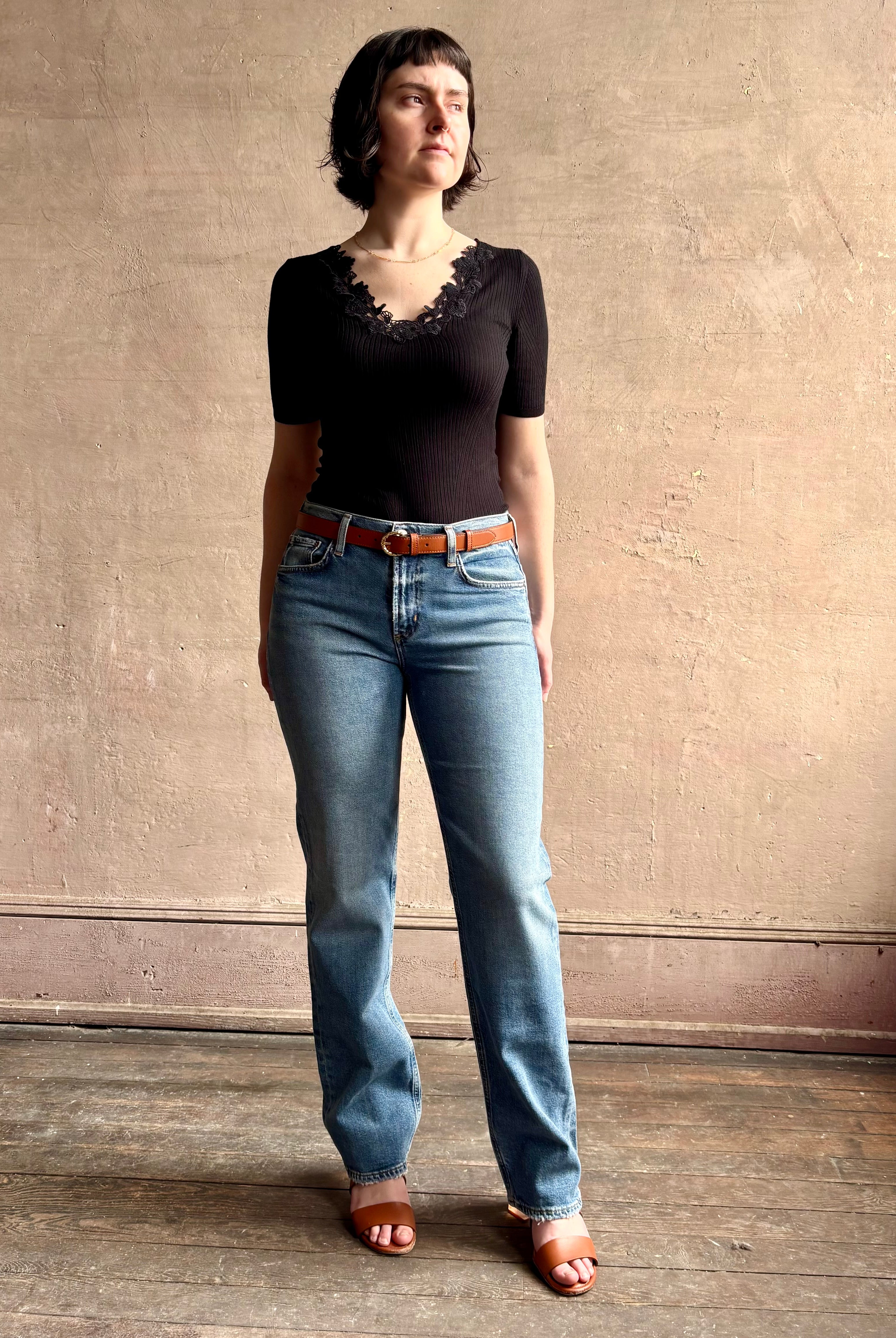 Woman wearing low rise slim denim from Agolde in Kindle medium wash with straight leg and finished hem line