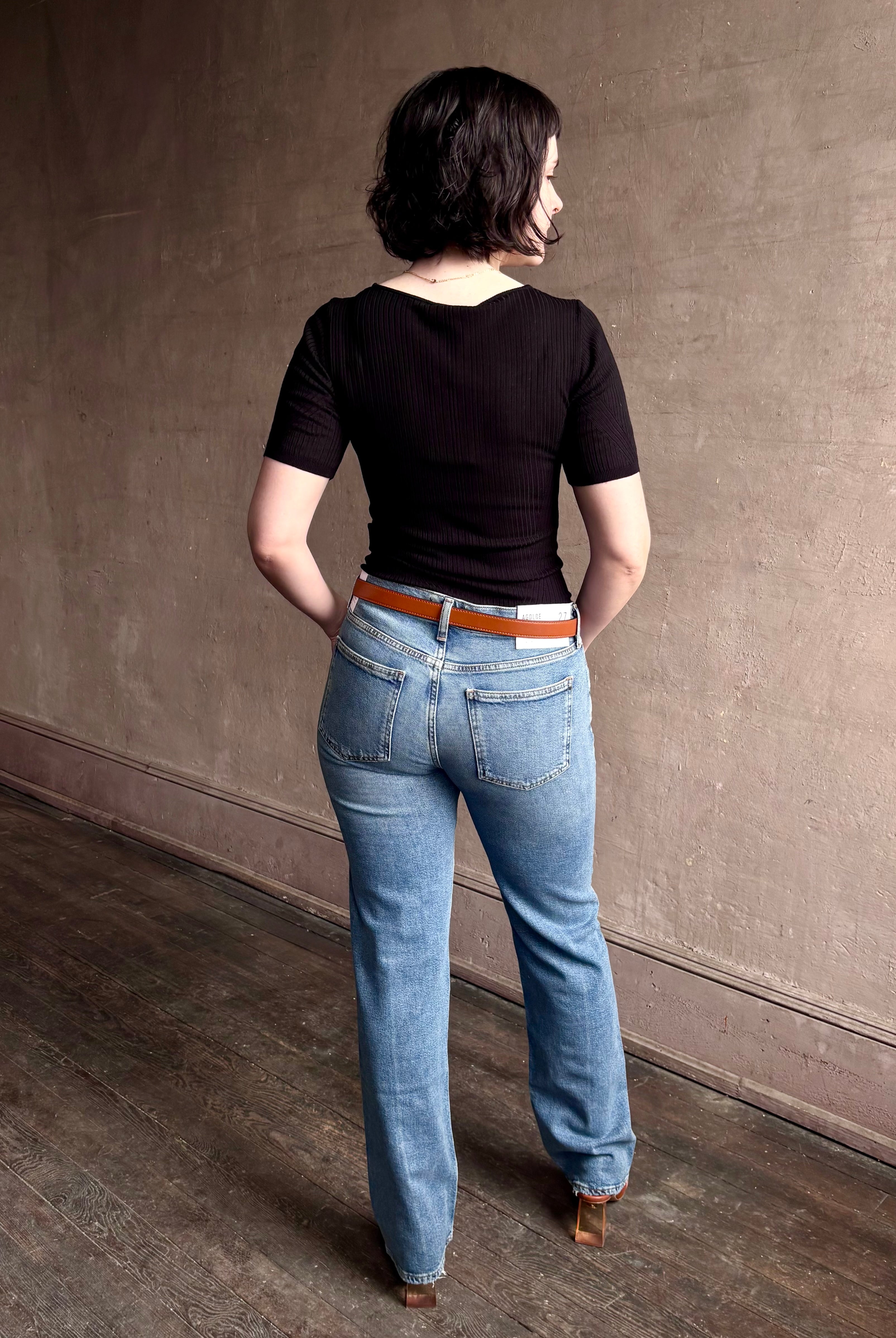 Woman wearing low rise slim denim from Agolde in Kindle medium wash with straight leg and finished hem line