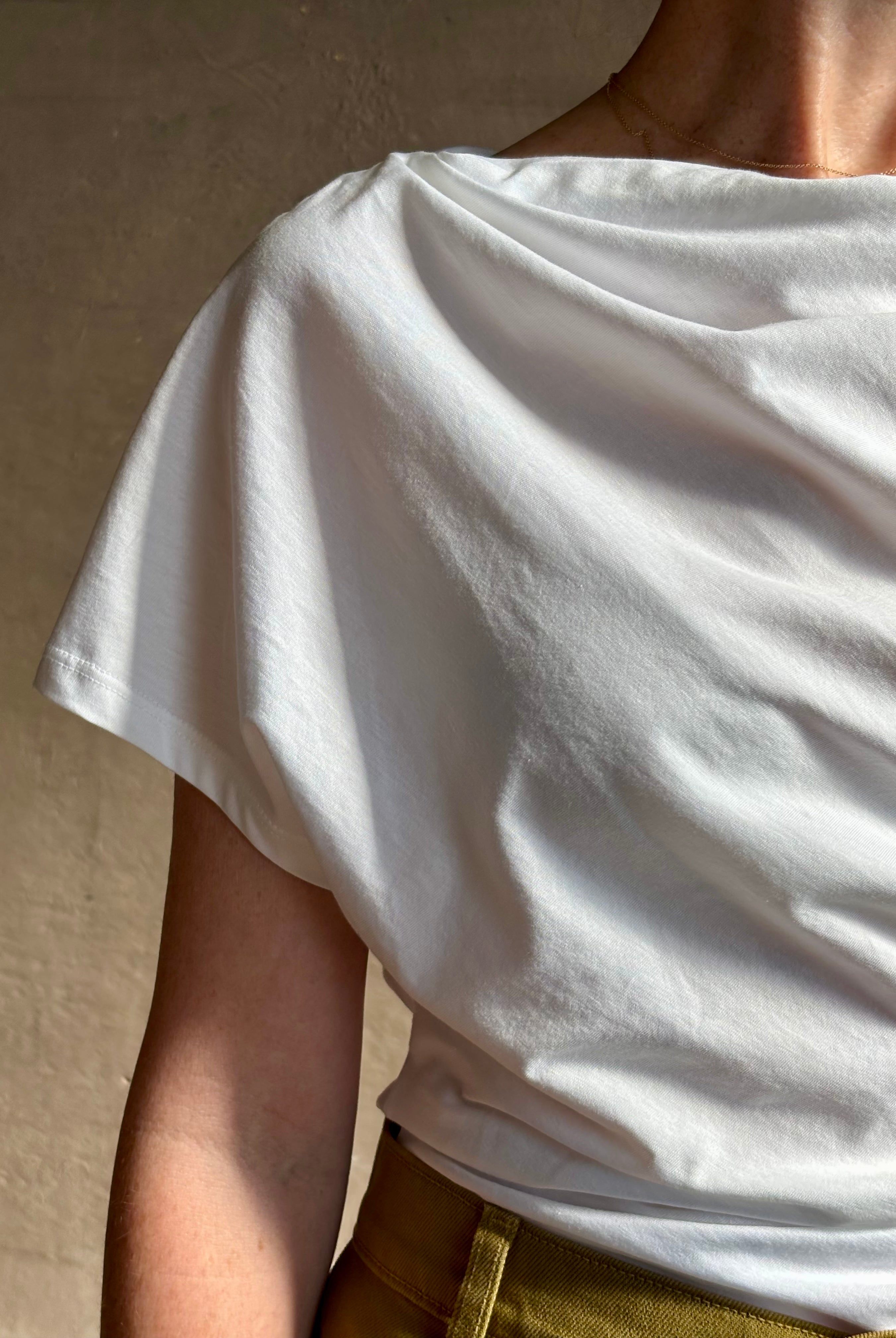 Mature woman wearing ALC Alice cotton t-shirt with ruched side and shoulder detail that can be worn asymmetrically in bright white
