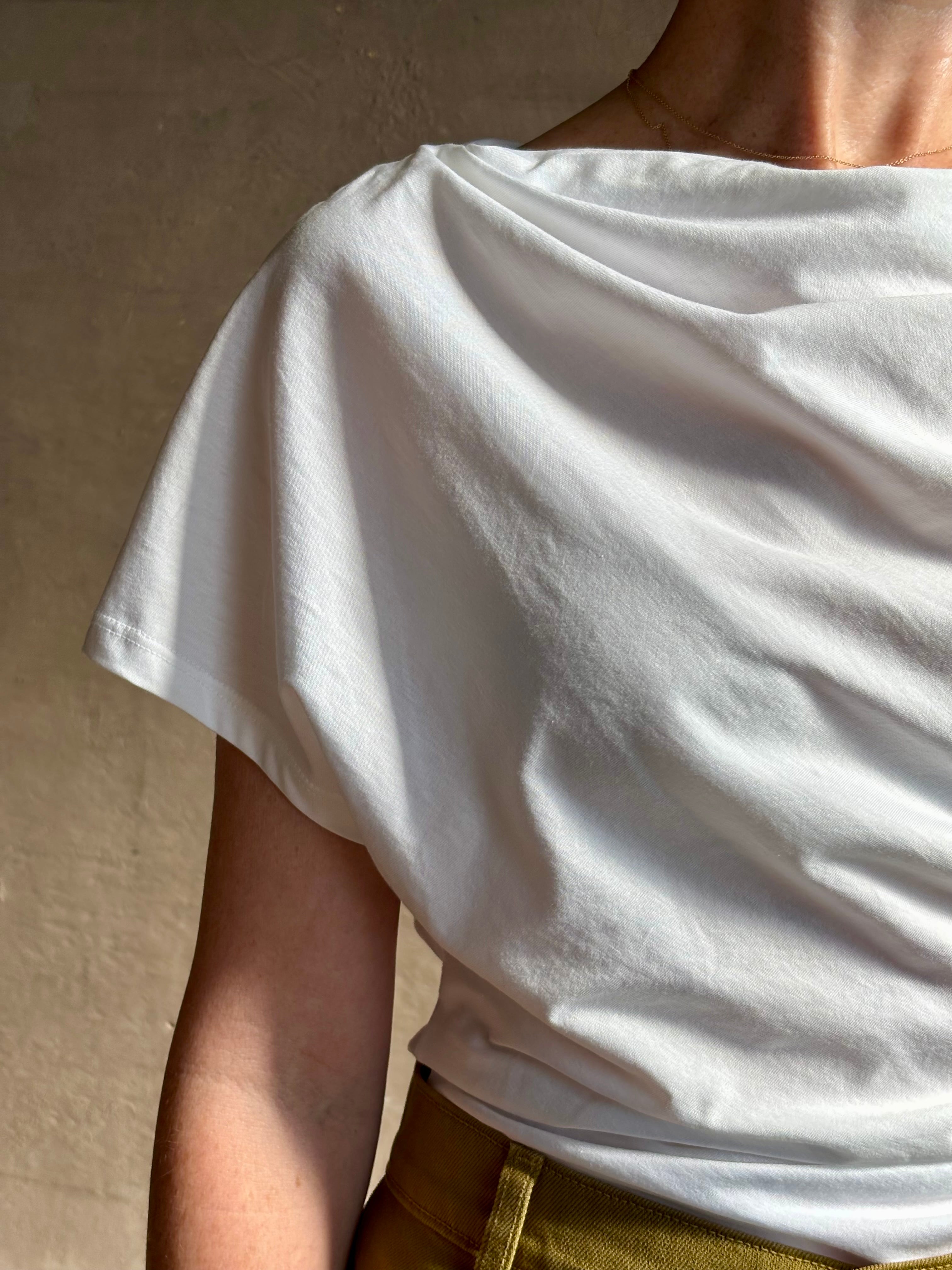 Mature woman wearing ALC Alice cotton t-shirt with ruched side and shoulder detail that can be worn asymmetrically in bright white