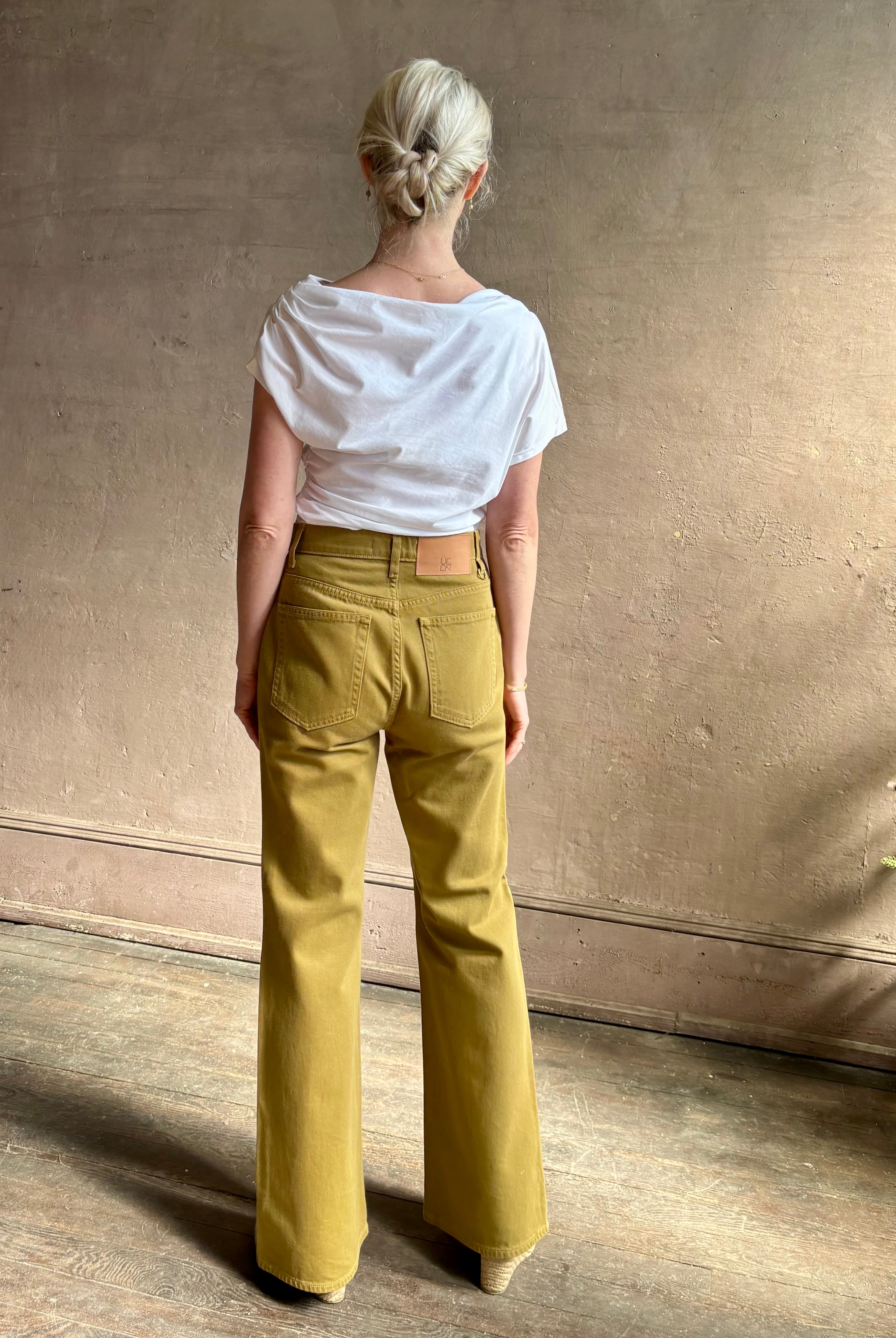 Mature woman wearing ALC Alice cotton t-shirt with ruched side and shoulder detail that can be worn asymmetrically in bright white