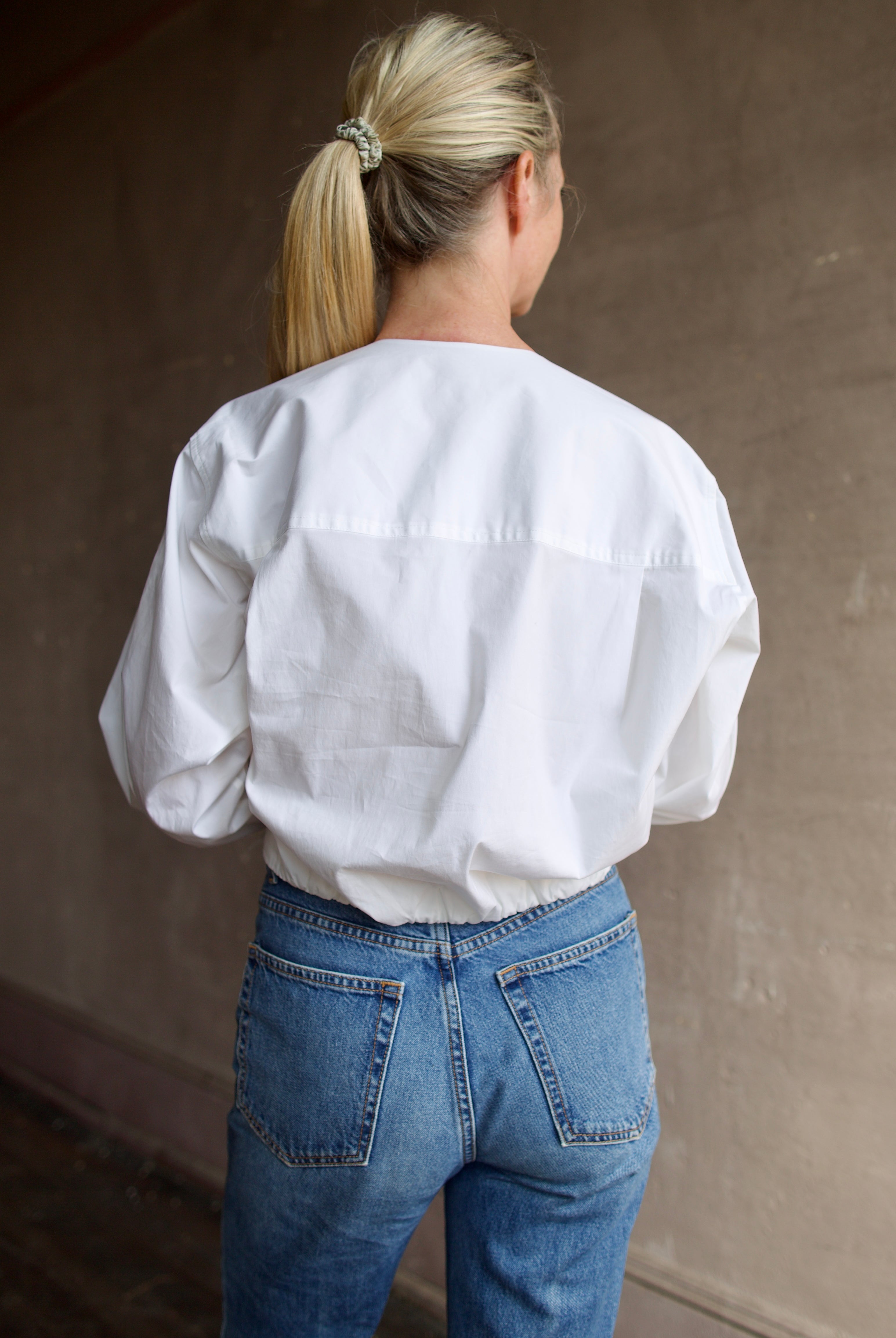 Model wearing The A.L.C. Jordan Top in White. Long sleeve blouse boasts premium cotton blend construction.