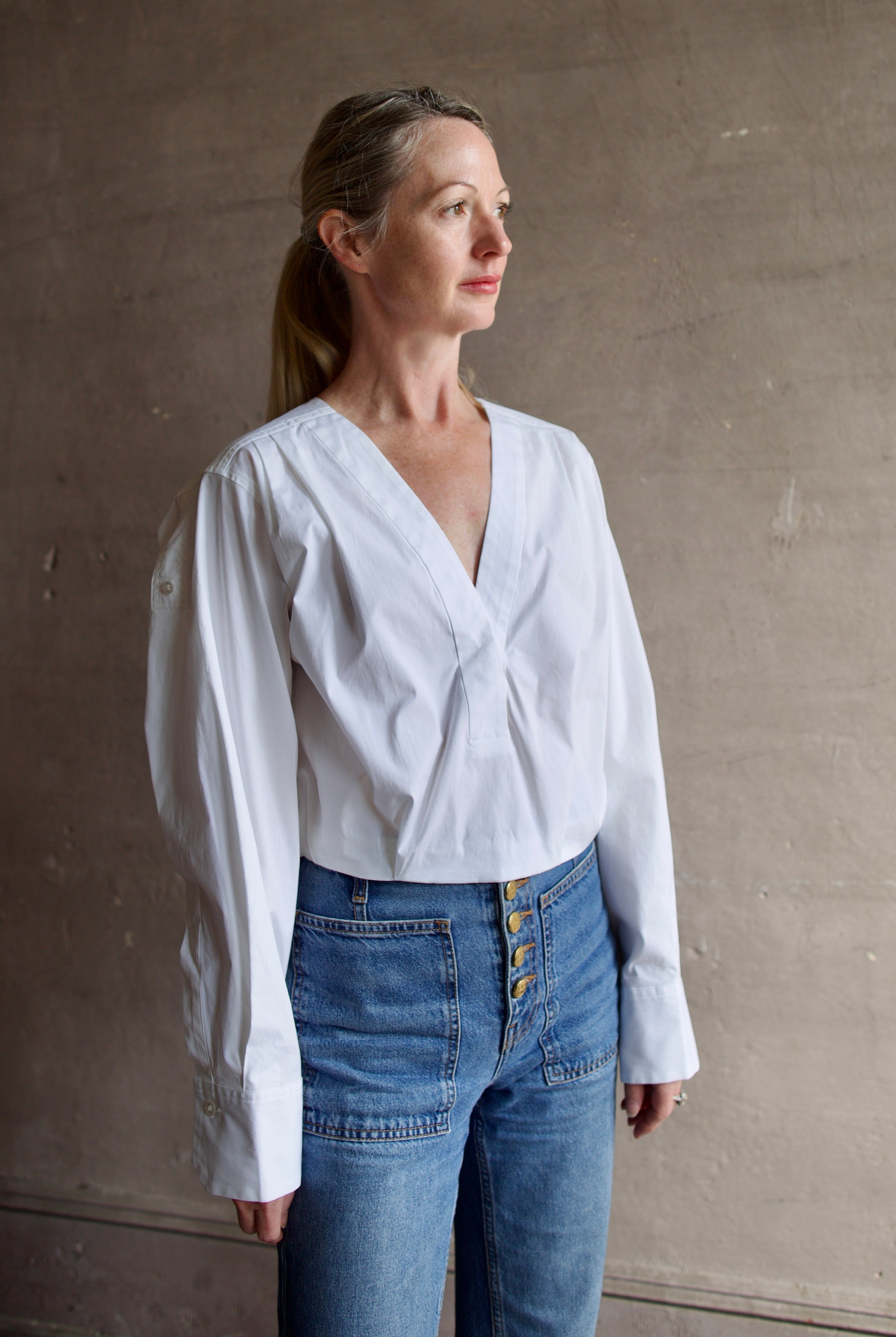 Model wearing The A.L.C. Jordan Top in White. Long sleeve blouse boasts premium cotton blend construction.