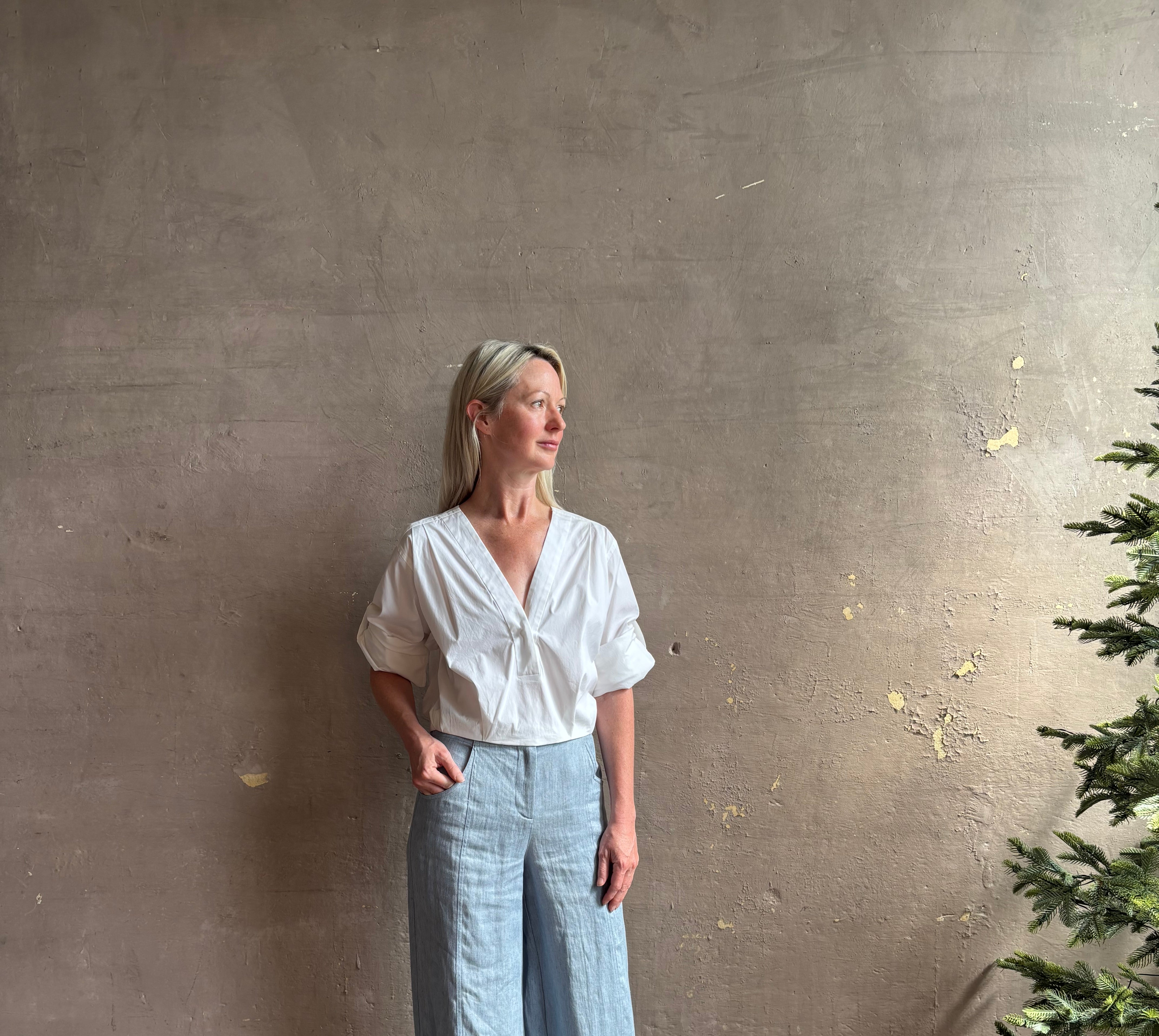 Mature woman wearing classic white cotton top by A.L.C. with v-neck and versatile sleeve options