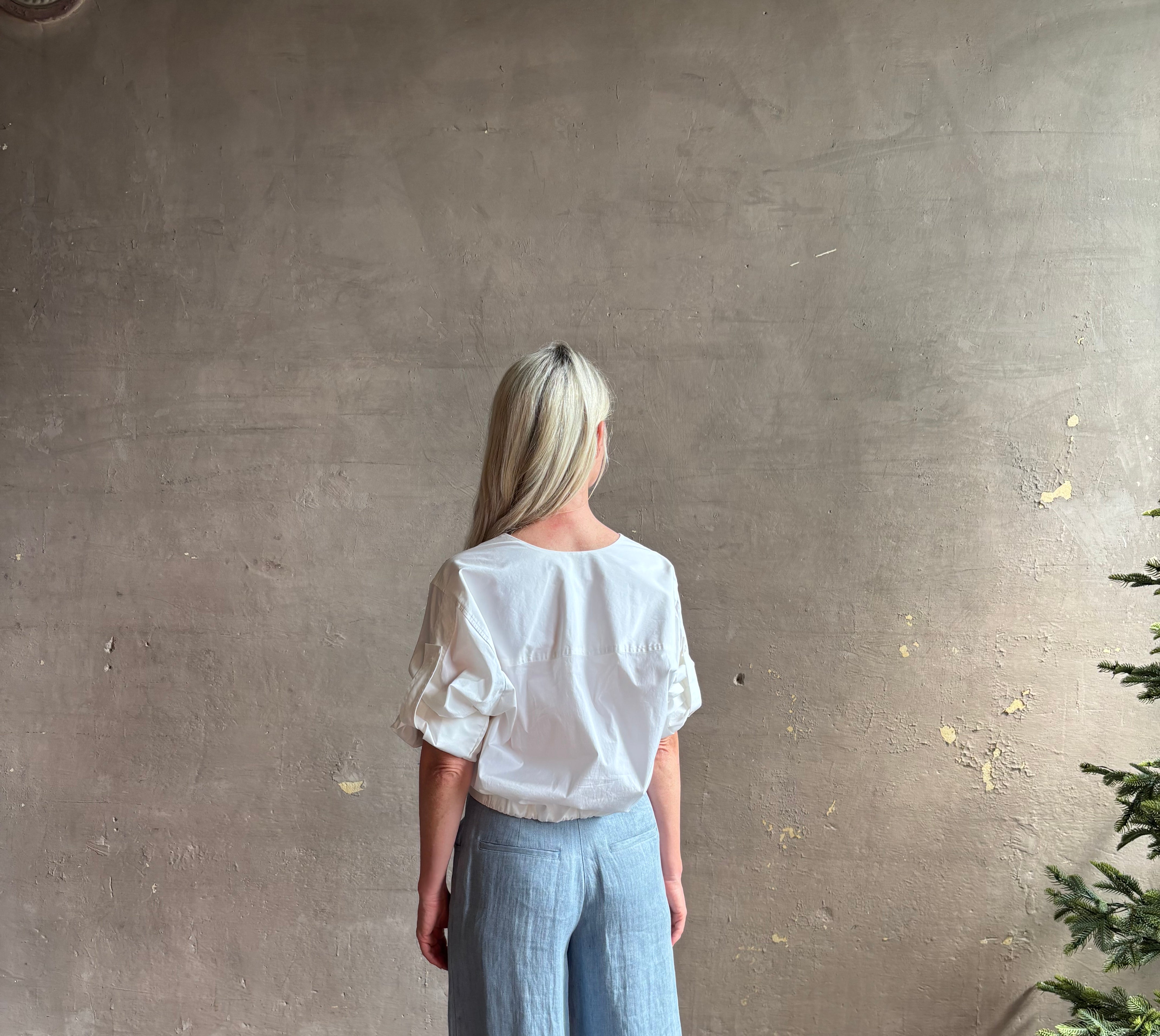 Mature woman wearing A.L.C. Jordan white crop Top in cotton blend with elasticized bottom at back