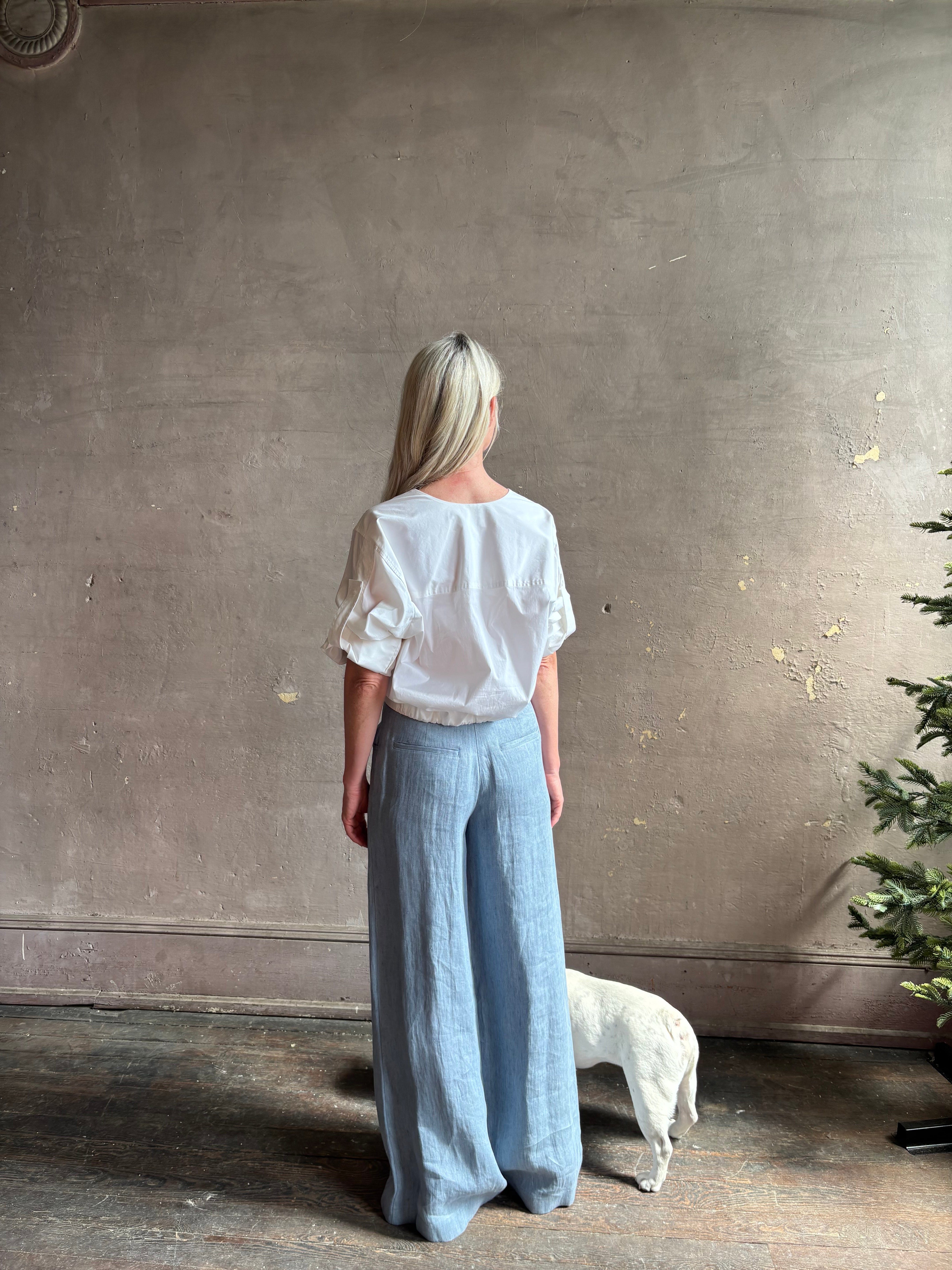 Mature woman wearing The A.L.C. Jordan Top in White Long sleeve blouse boasts premium cotton blend with v-neck and tab to roll sleeves up to a half sleeve