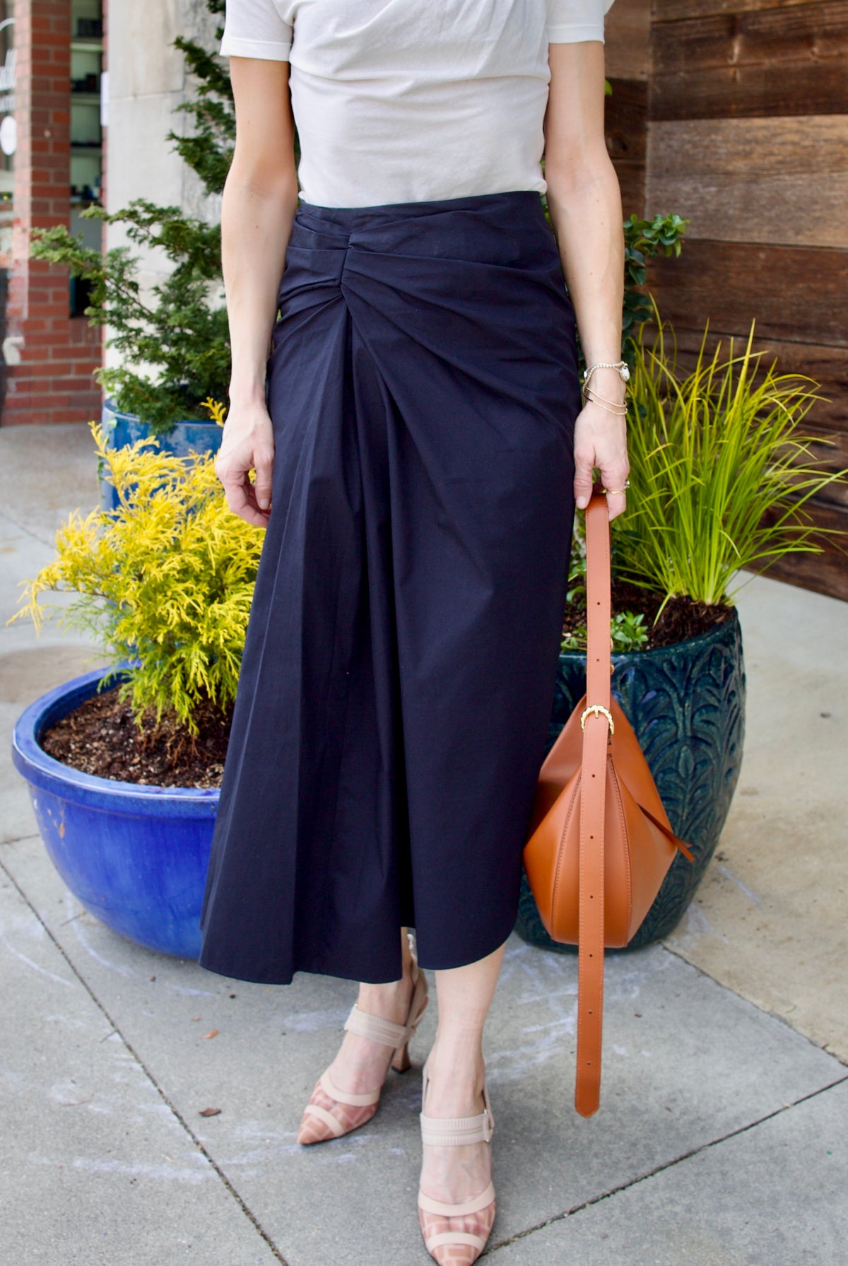 Image of woman wearing luxury women's cotton ALC Tessa skirt with ruched waistband with asymmetrical hem line