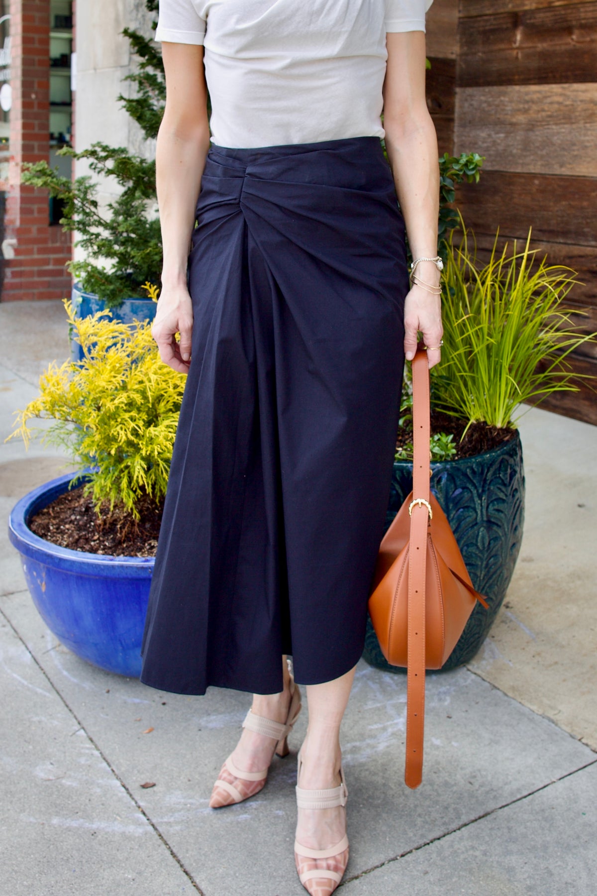 Image of woman wearing luxury women's cotton ALC Tessa skirt with ruched waistband with asymmetrical hem line