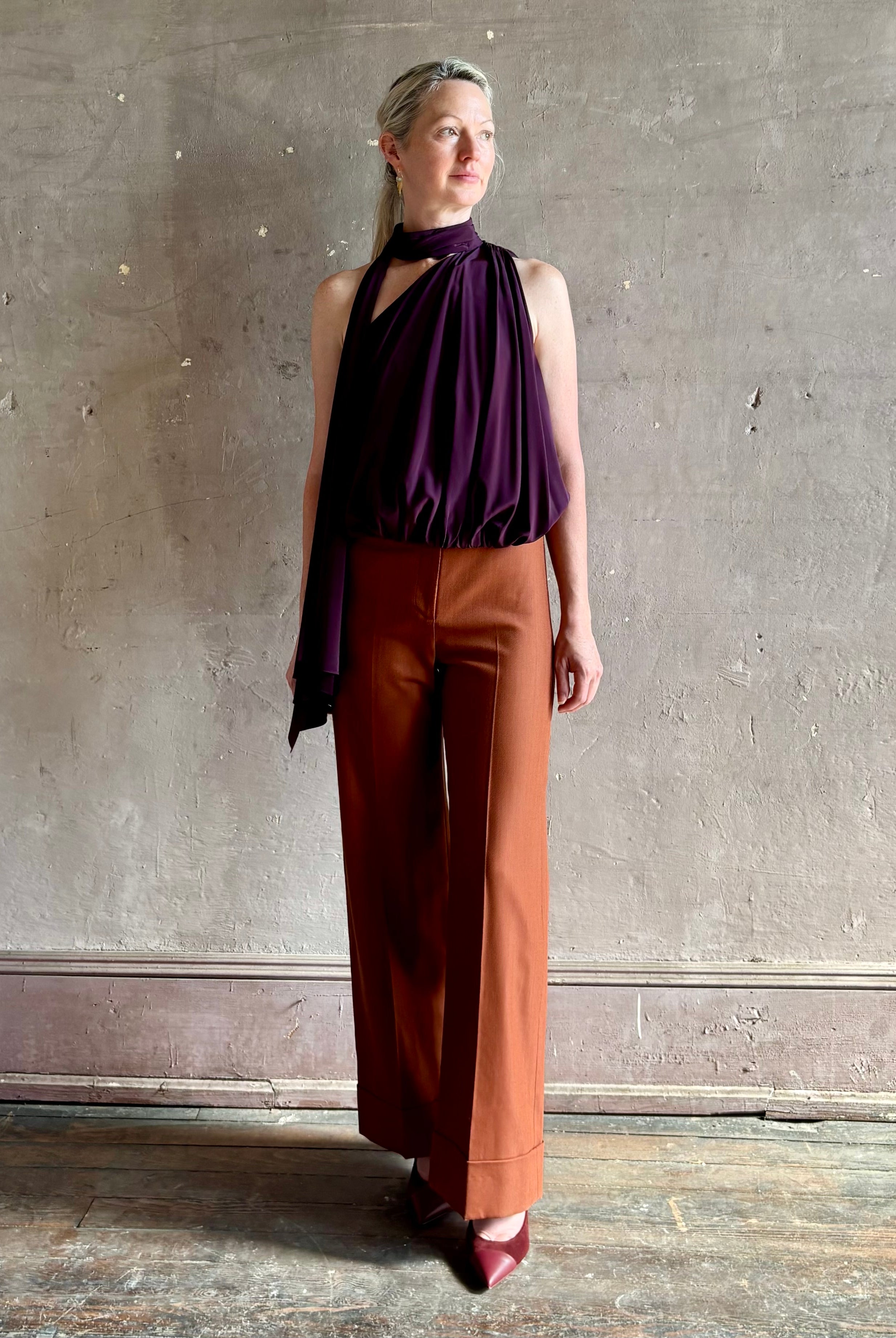 Mature model wearing ALC silk celeste top with one shoulder halter neck closure attached scarf fluid elevated