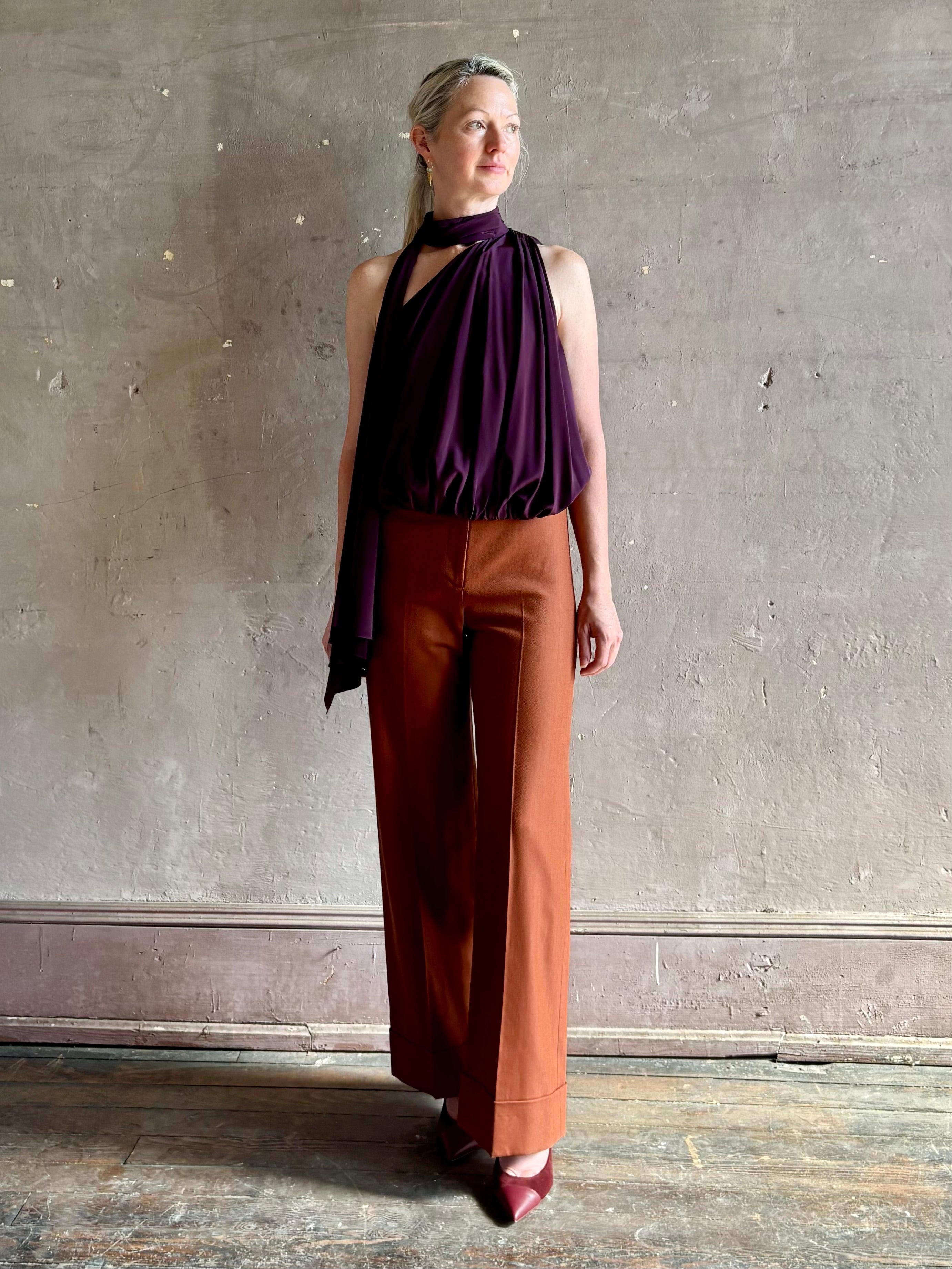 Mature model wearing ALC silk celeste top with one shoulder halter neck closure attached scarf fluid elevated