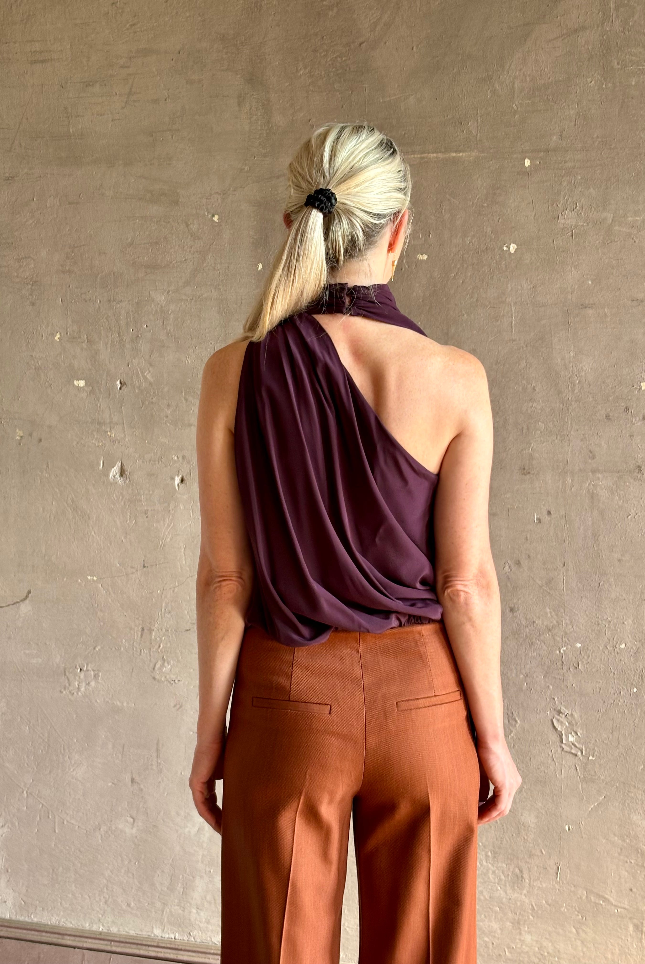 Mature model wearing ALC silk celeste top with one shoulder halter neck attached scarf sophisticated draping