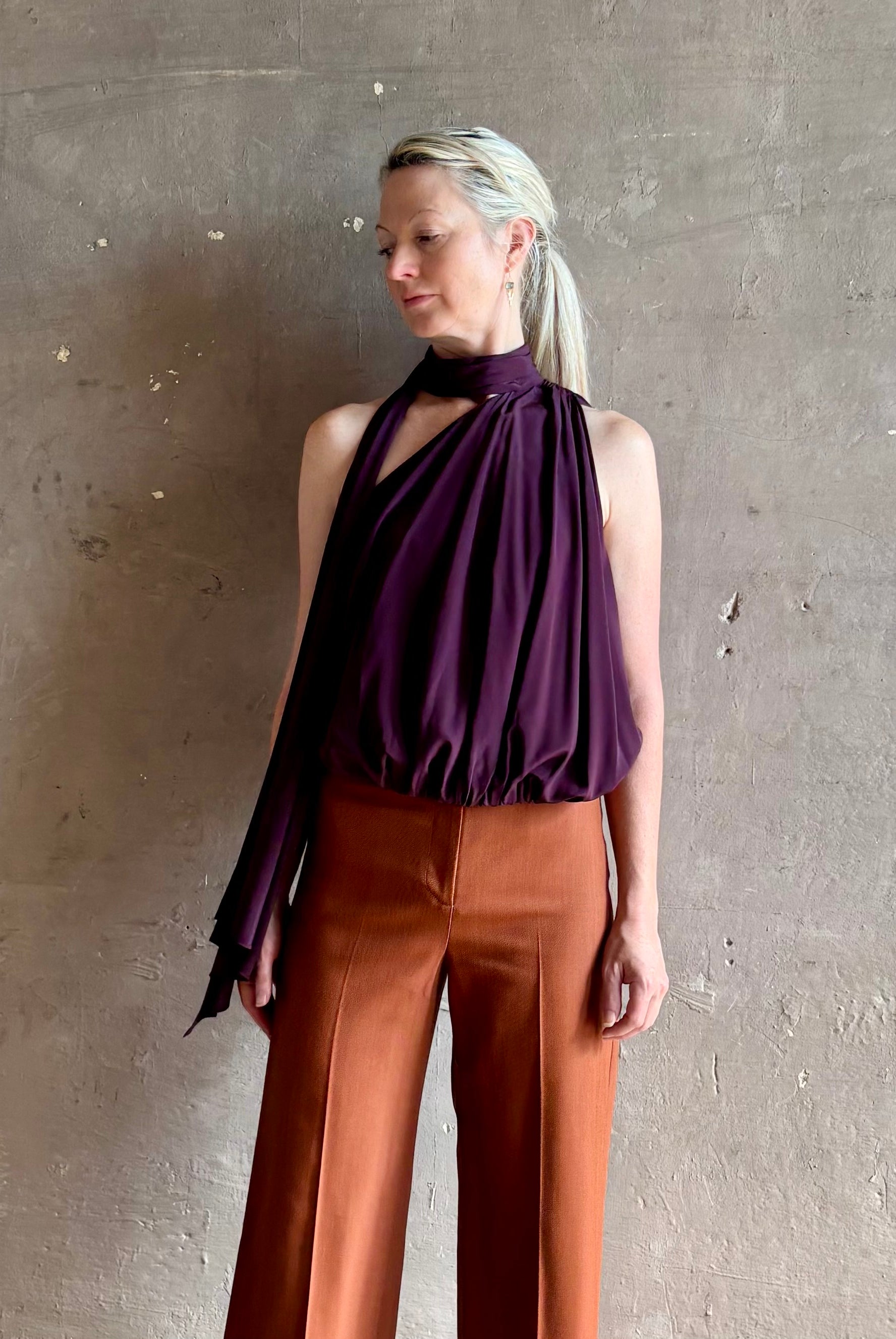Mature model wearing ALC silk celeste top with one shoulder halter neck attached scarf sophisticated draping