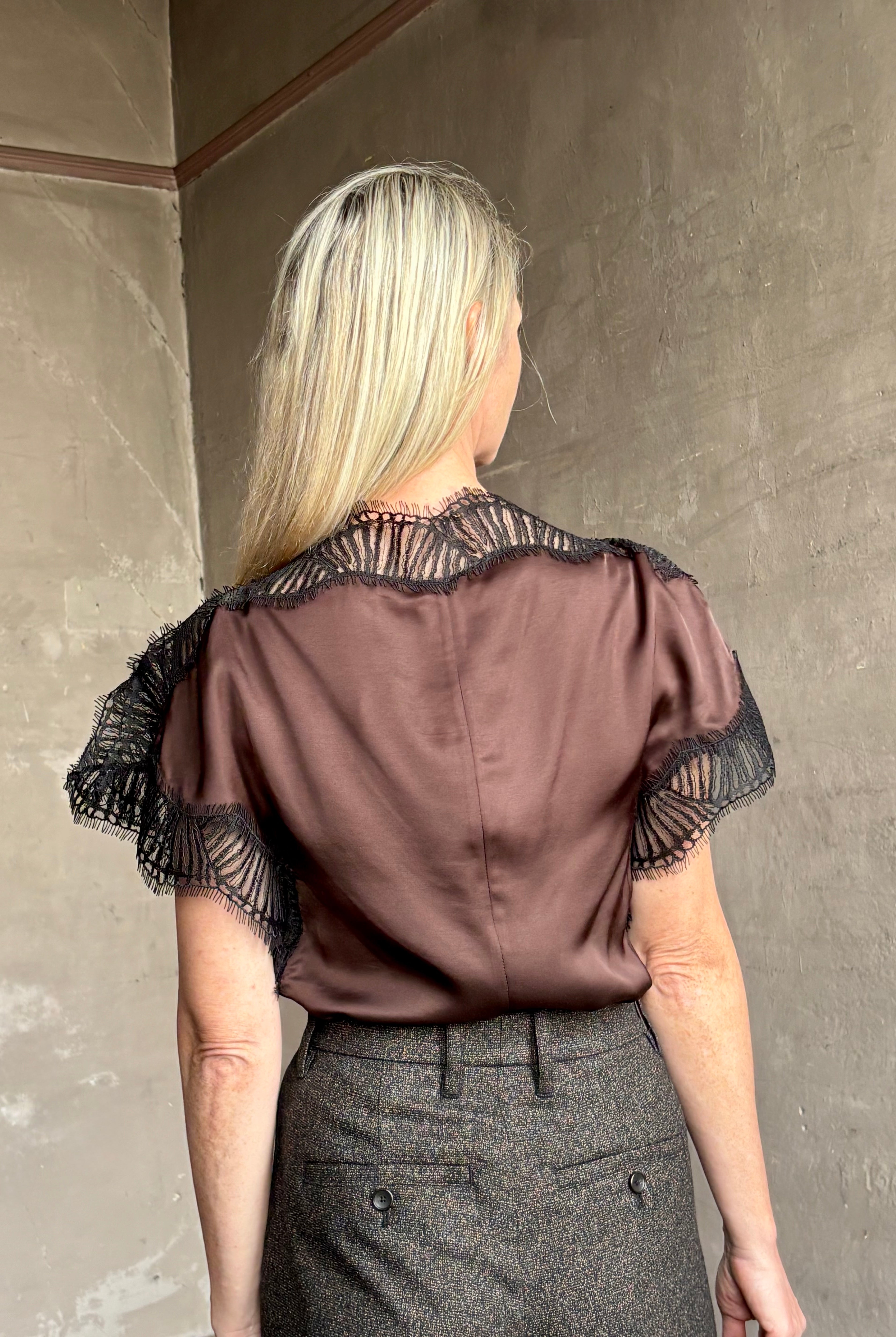 Image of mature woman wearing ALC Luna top in premium chocolate brown viscose blouse with a boat neck short sleeve and refined black lace trim