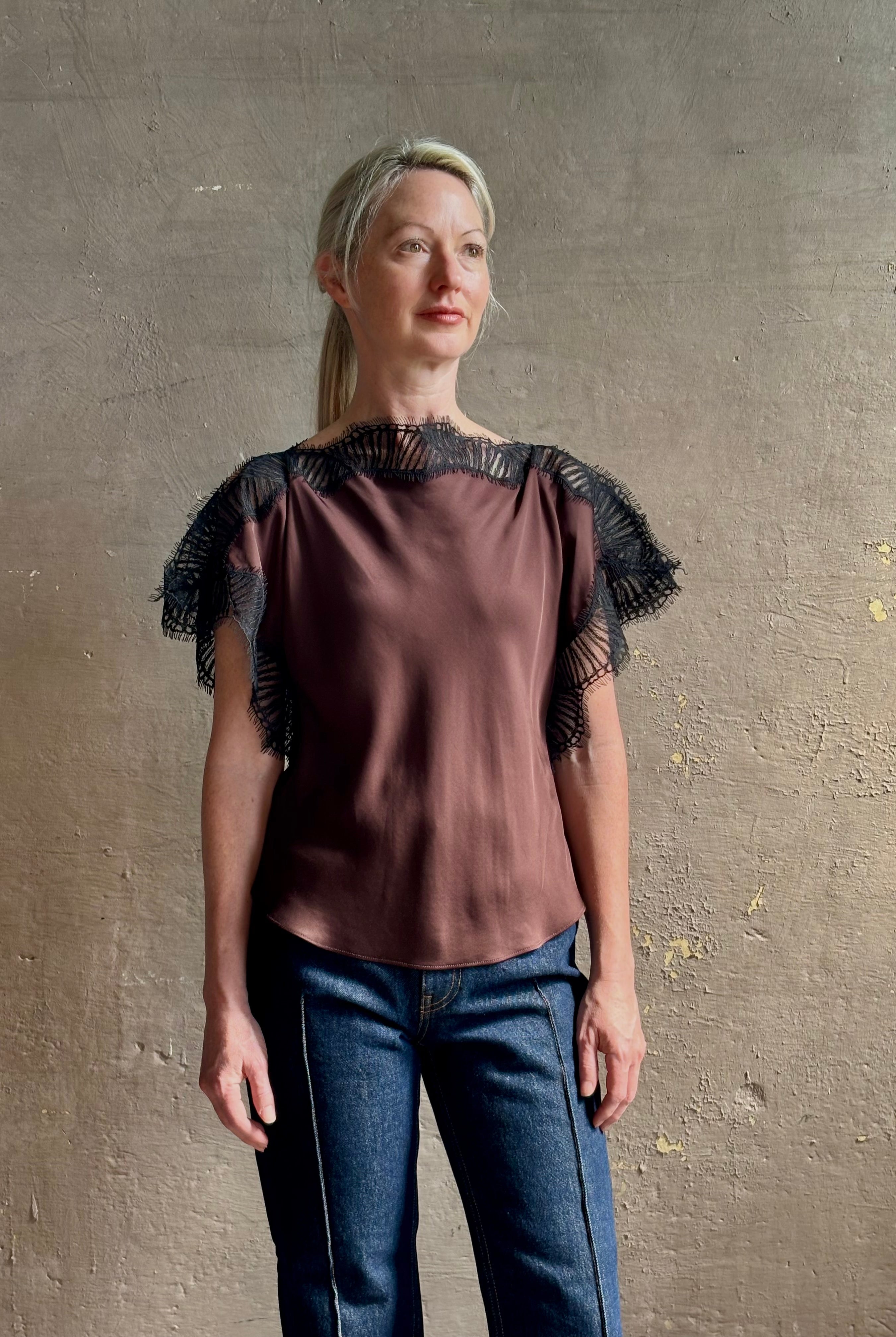 Image of mature woman wearing ALC Luna top in premium chocolate brown viscose blouse with a boat neck short sleeve and refined black lace trim