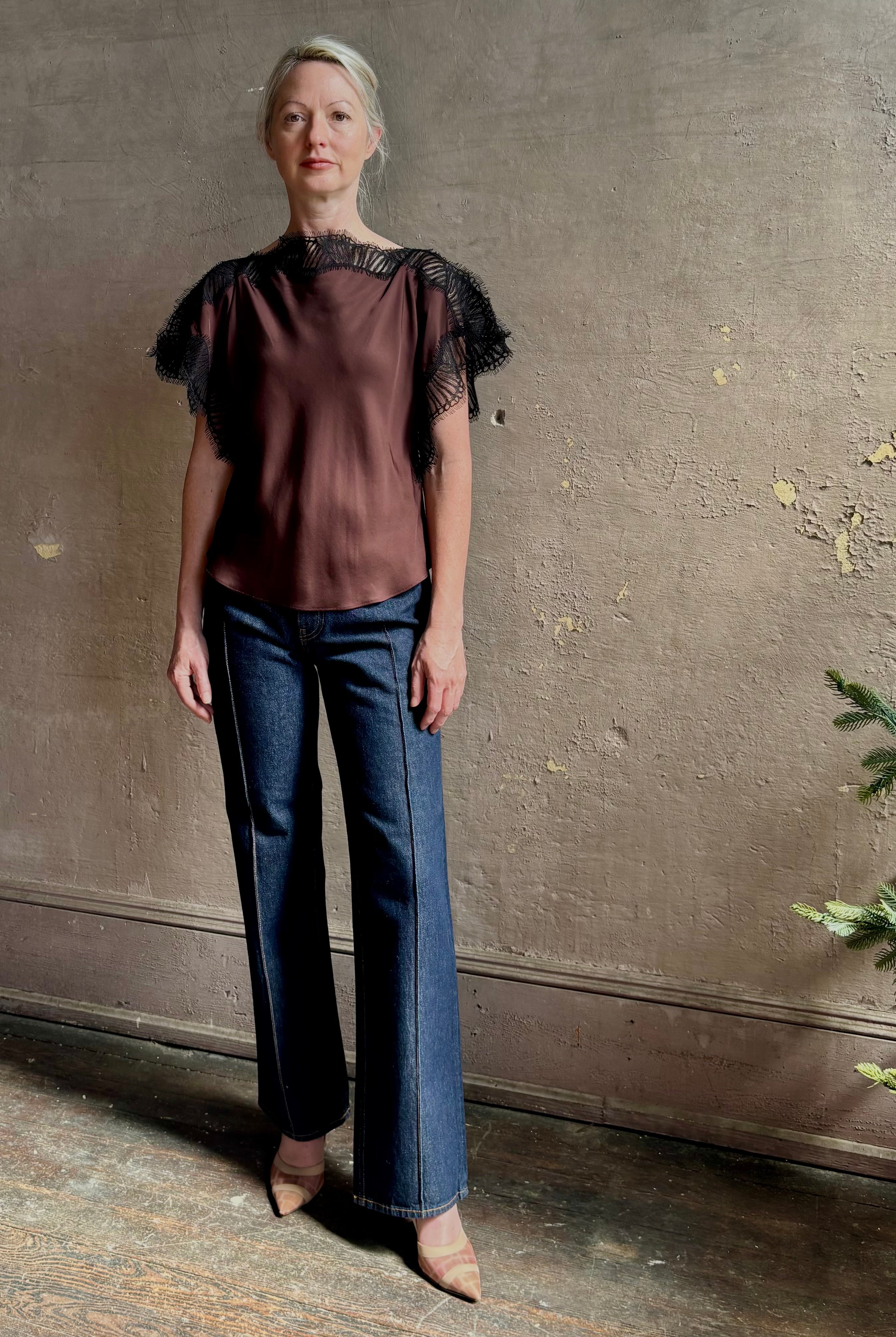 Image of mature woman wearing ALC Luna top in premium chocolate brown viscose blouse with a boat neck short sleeve and refined black lace trim