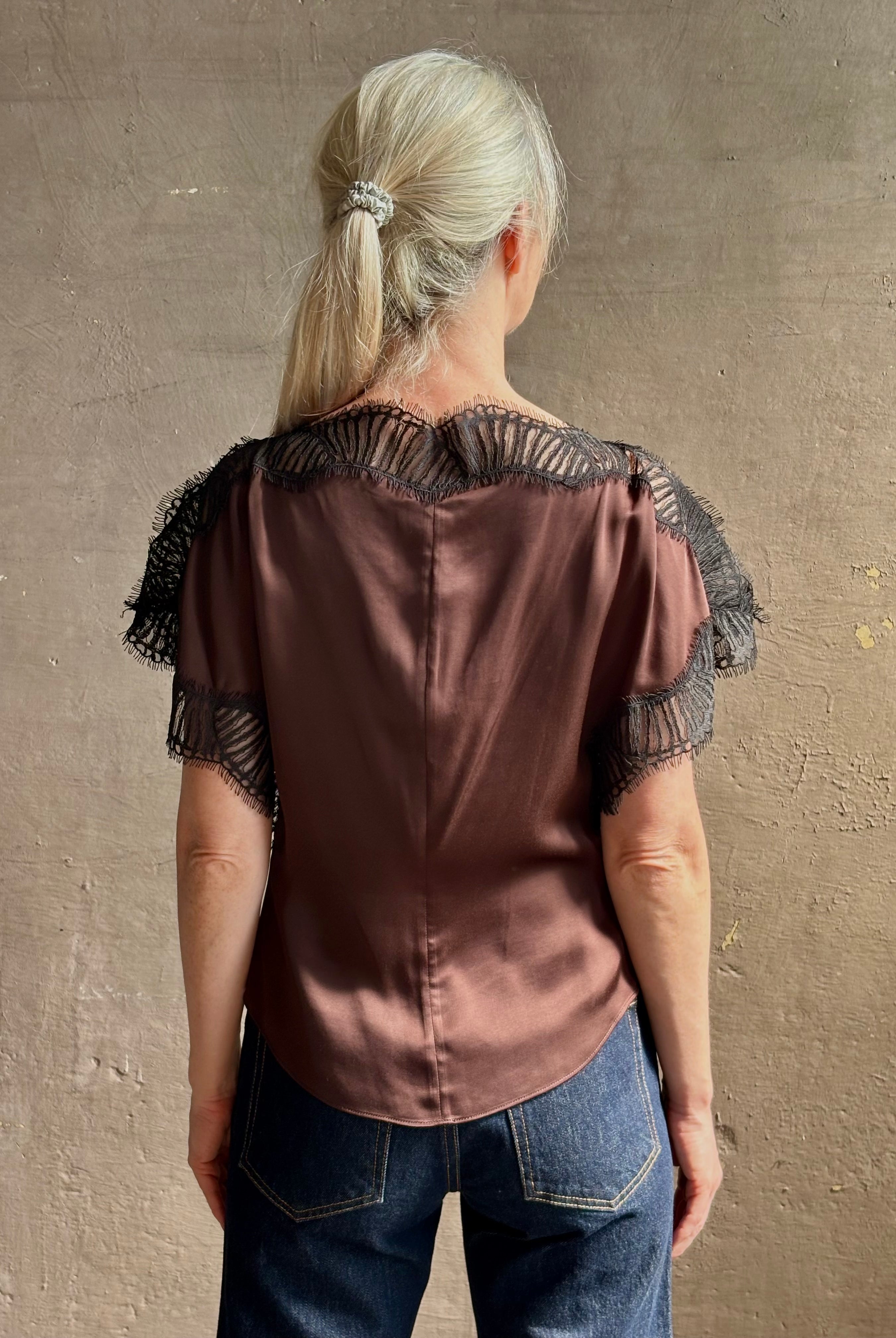 Image of mature woman wearing ALC Luna top in premium chocolate brown viscose blouse with a boat neck short sleeve and refined black lace trim