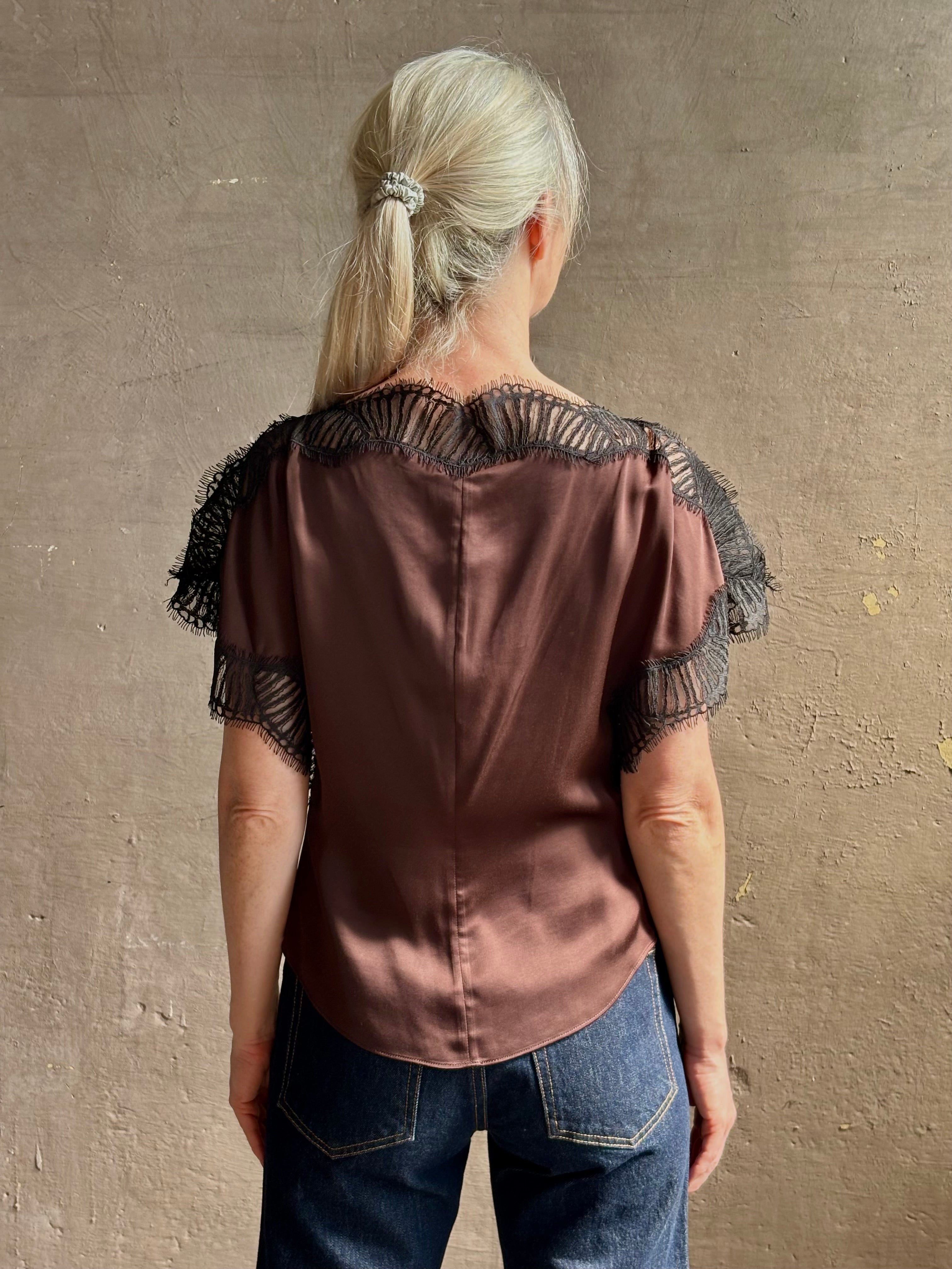 Image of mature woman wearing ALC Luna top in premium chocolate brown viscose blouse with a boat neck short sleeve and refined black lace trim