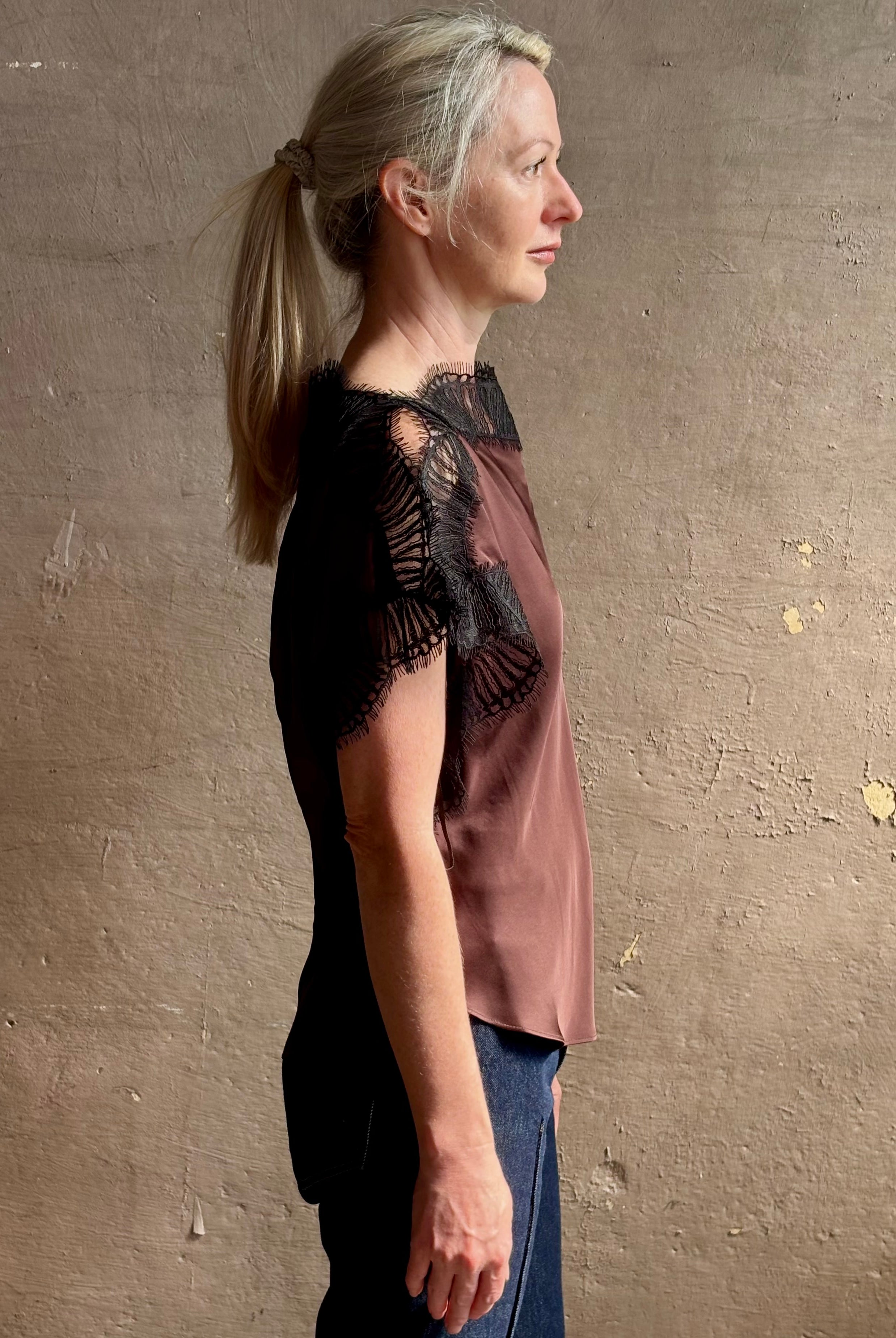 Image of mature woman wearing ALC Luna top in premium chocolate brown viscose blouse with a boat neck short sleeve and refined black lace trim