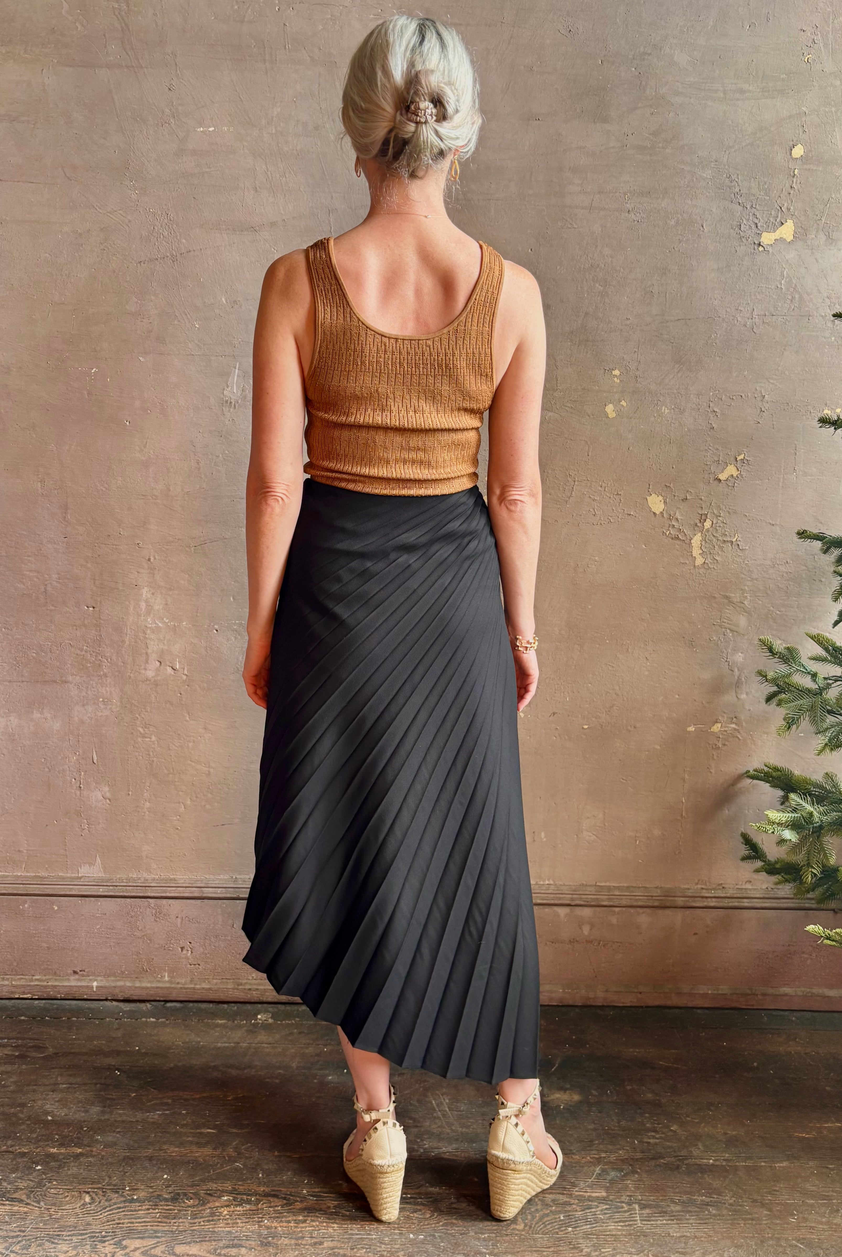 Mature woman wearing ALC Tracy skirt in black wool with asymetrical hemline and pleating