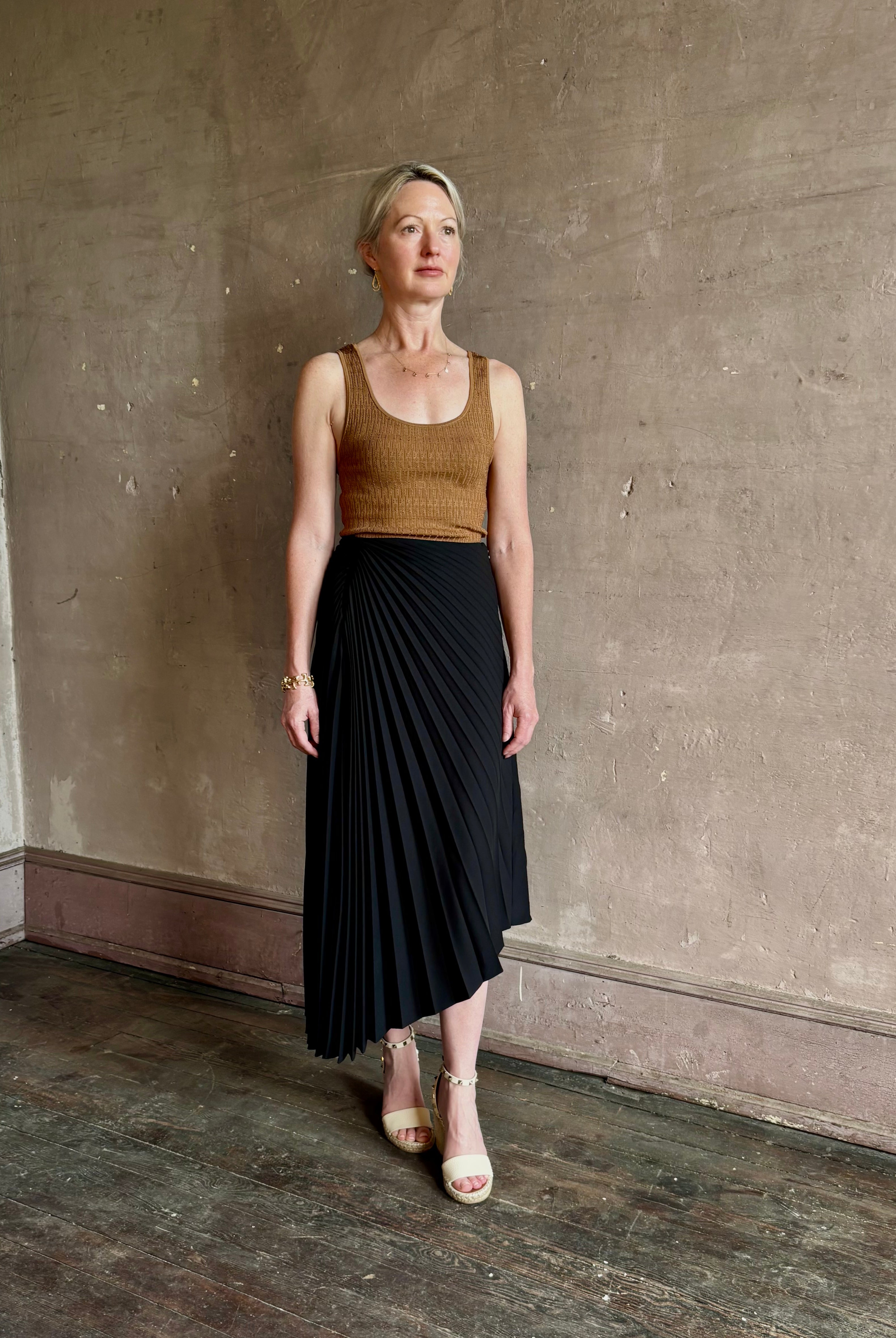 Mature woman wearing ALC Tracy skirt in black wool with asymetrical hemline and pleating