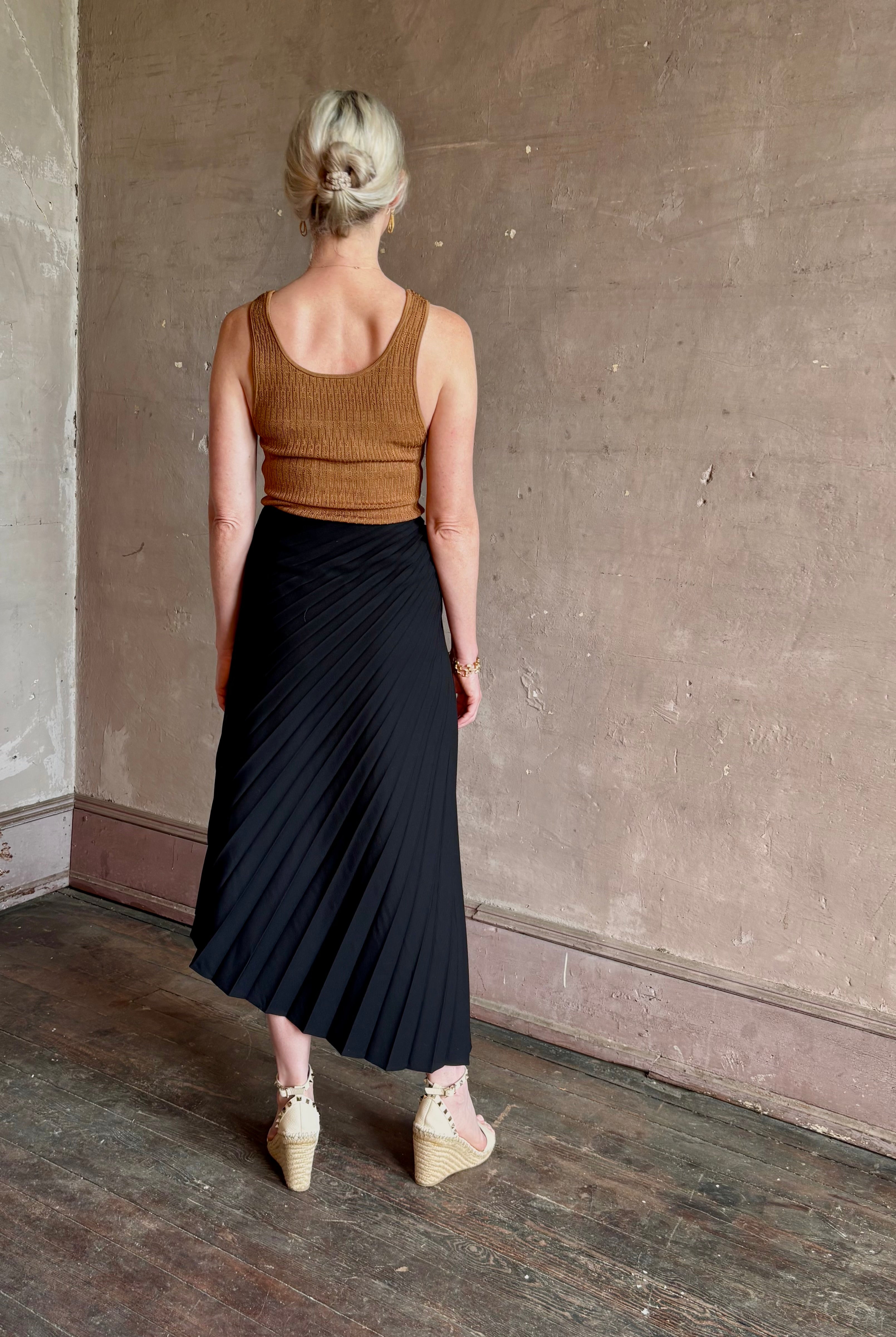 Mature woman wearing ALC Tracy skirt in black wool with asymetrical hemline and pleating
