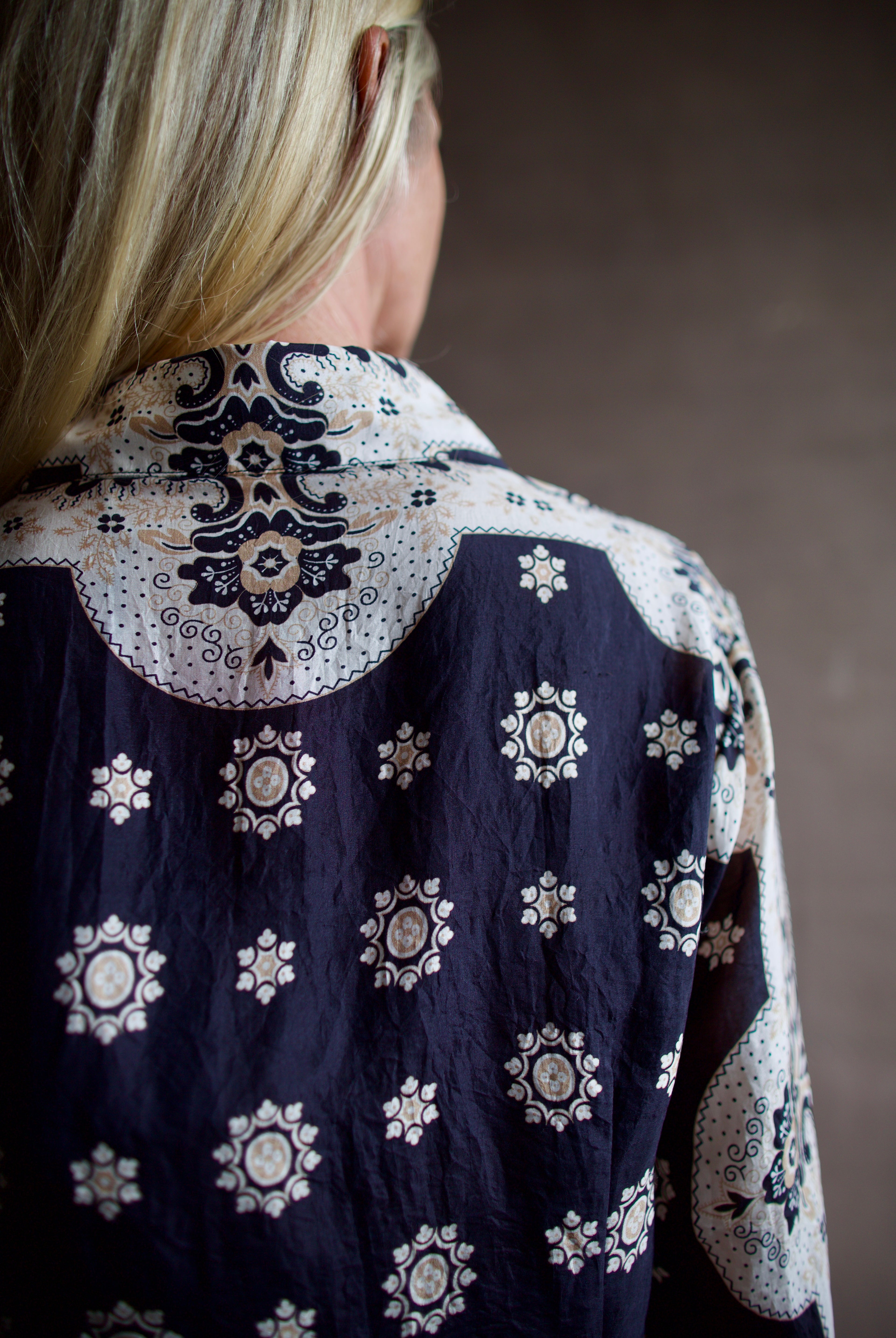 Model wearing a black and white Alix of Bohemia bandana blouse and silk beige Alix trousers