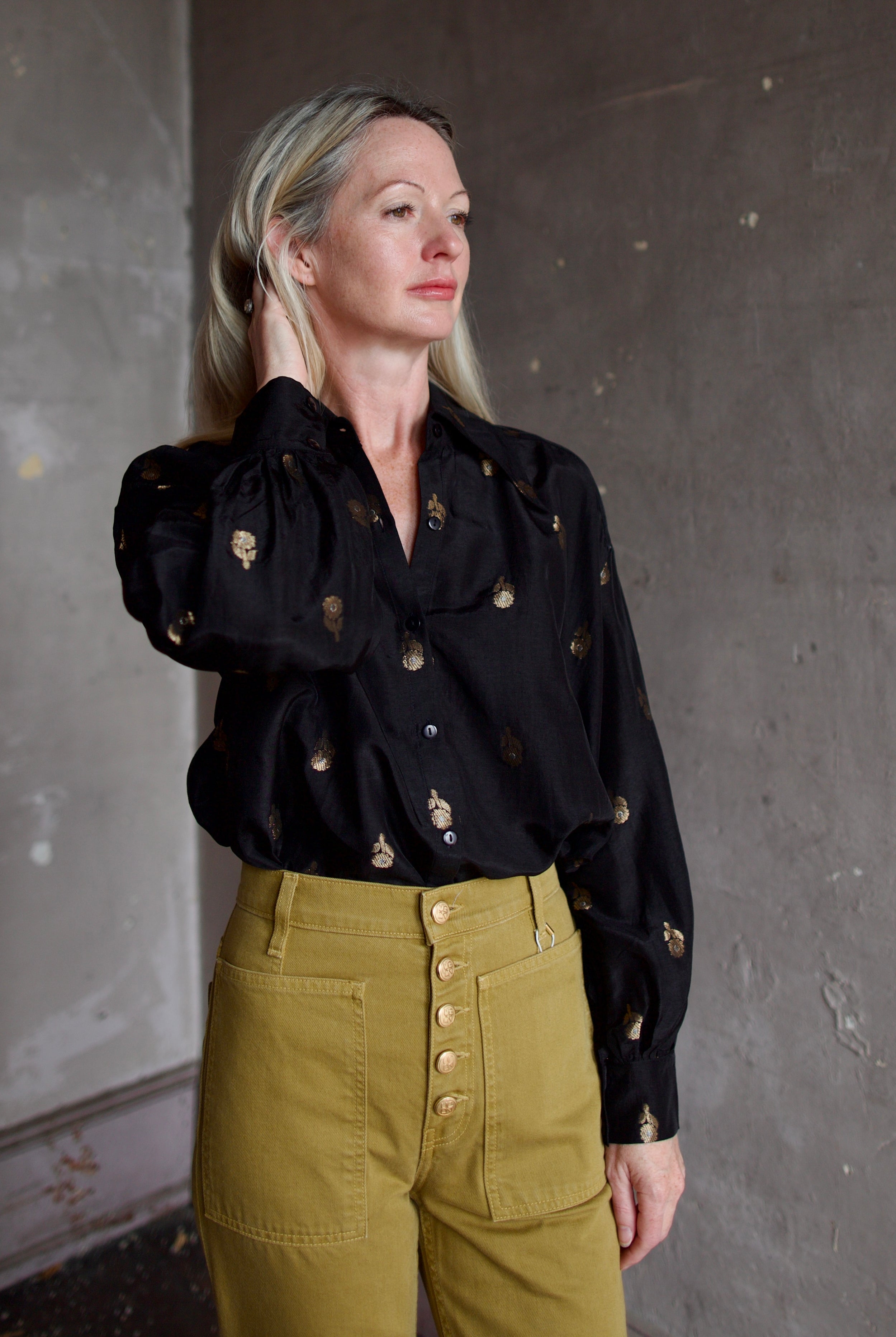 Model wearing Alix of Bohemia Emery Shadow Shirt. Black shirt has bamboo construction and subtle gold metallic accents.