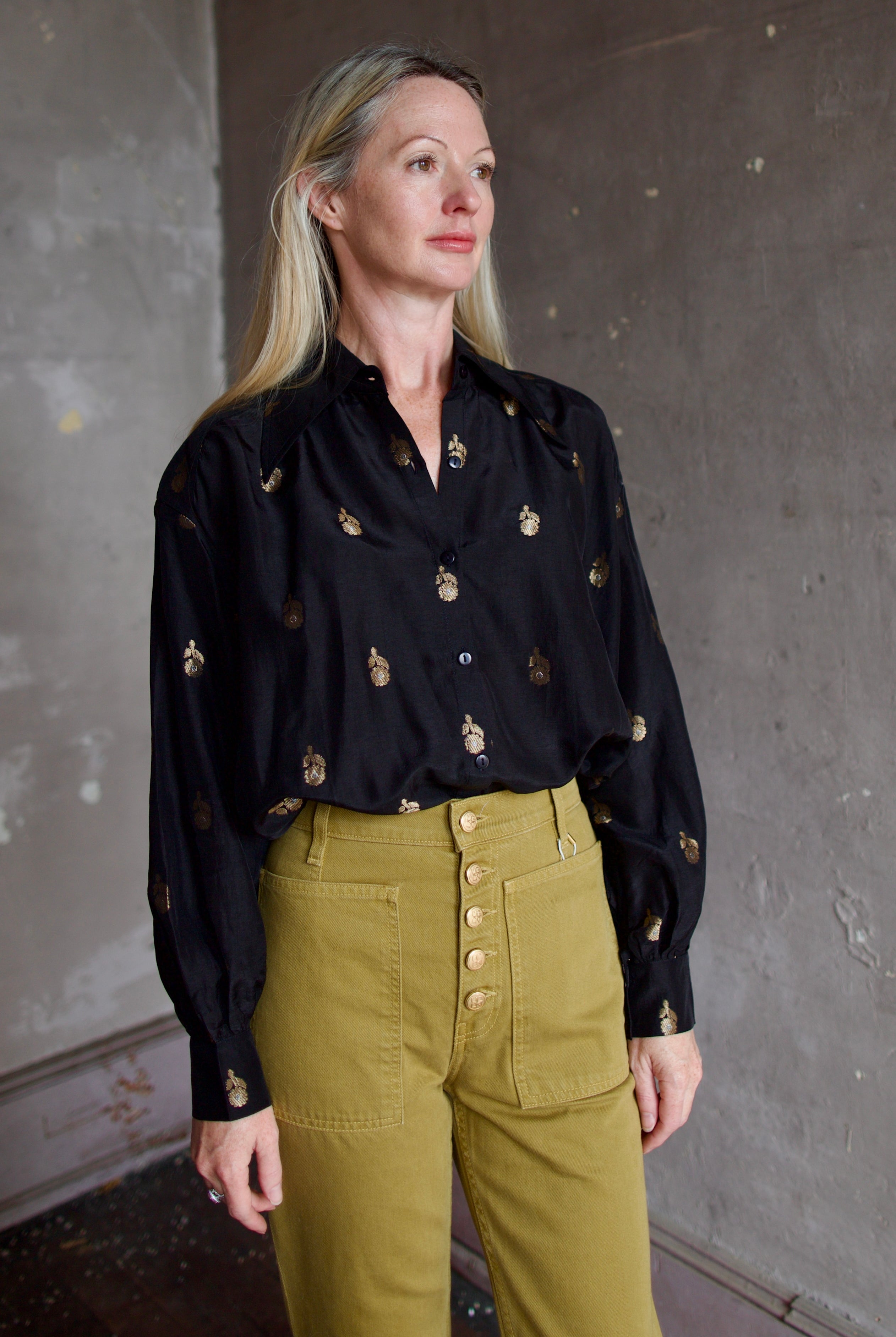 Model wearing Alix of Bohemia Emery Shadow Shirt. Black shirt has bamboo construction and subtle gold metallic accents.