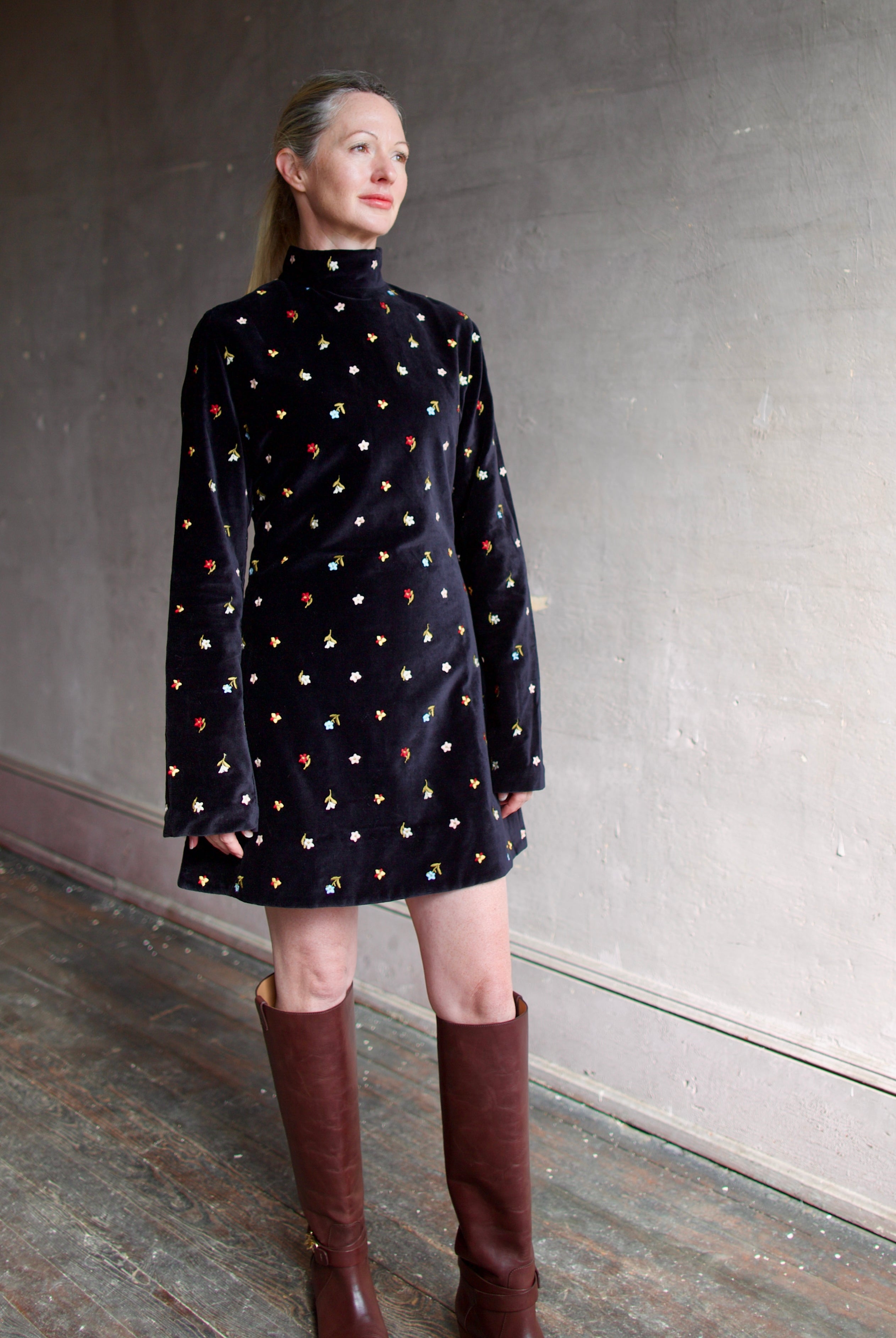 Model wearing Alix of Bohemia Romy Onyx Bouquet Dress. Premium cotton construction of black mini dress with flower bud details with luxurious silk-blend lining.