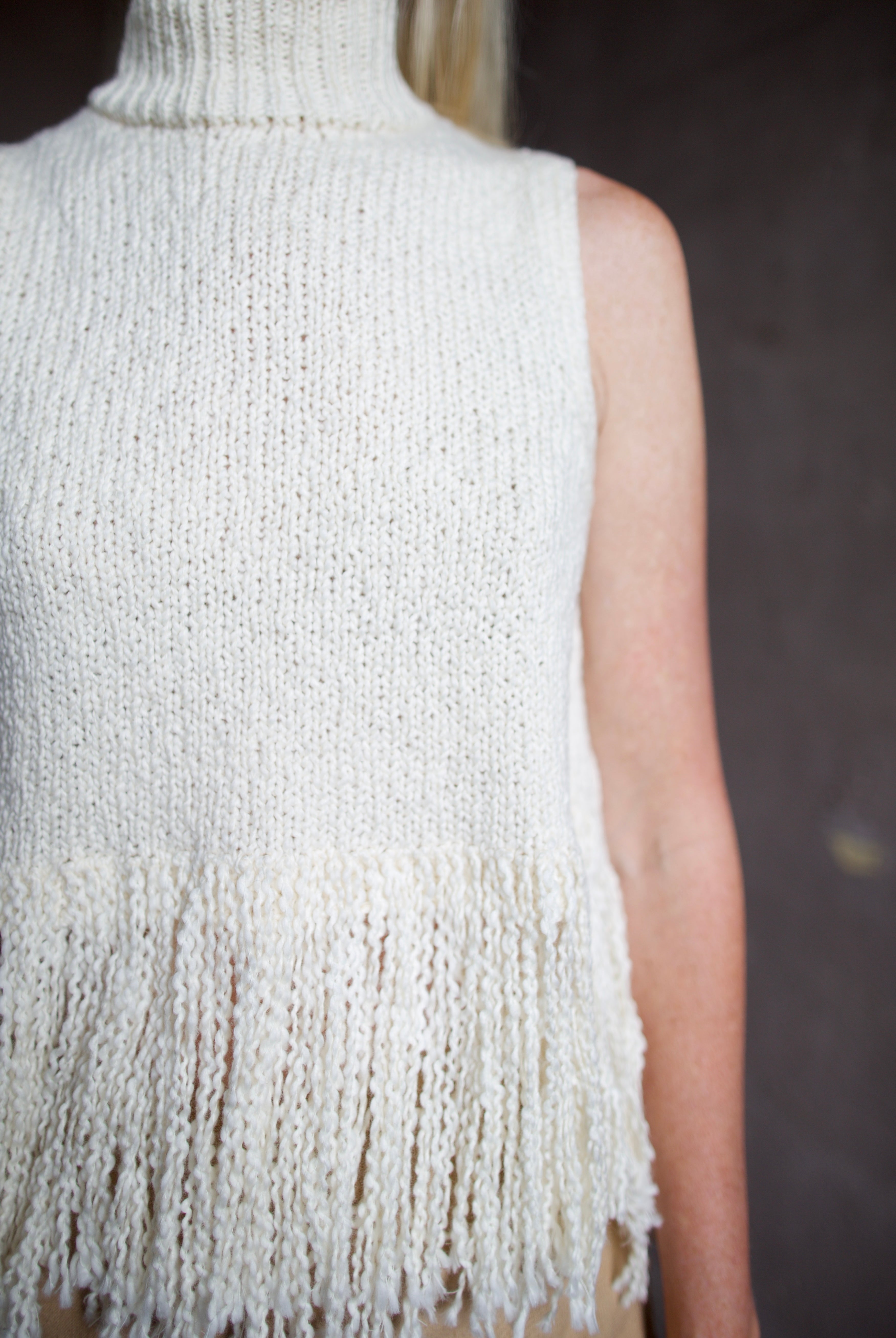 Back of an Alix of Bohemia cream sleeveless cotton sweater with fringe trimmed top