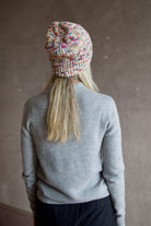 Model wearing Alix of Bohemia Yara Aurora Beanie. Knitted beanie is multicolored with cuff detail.