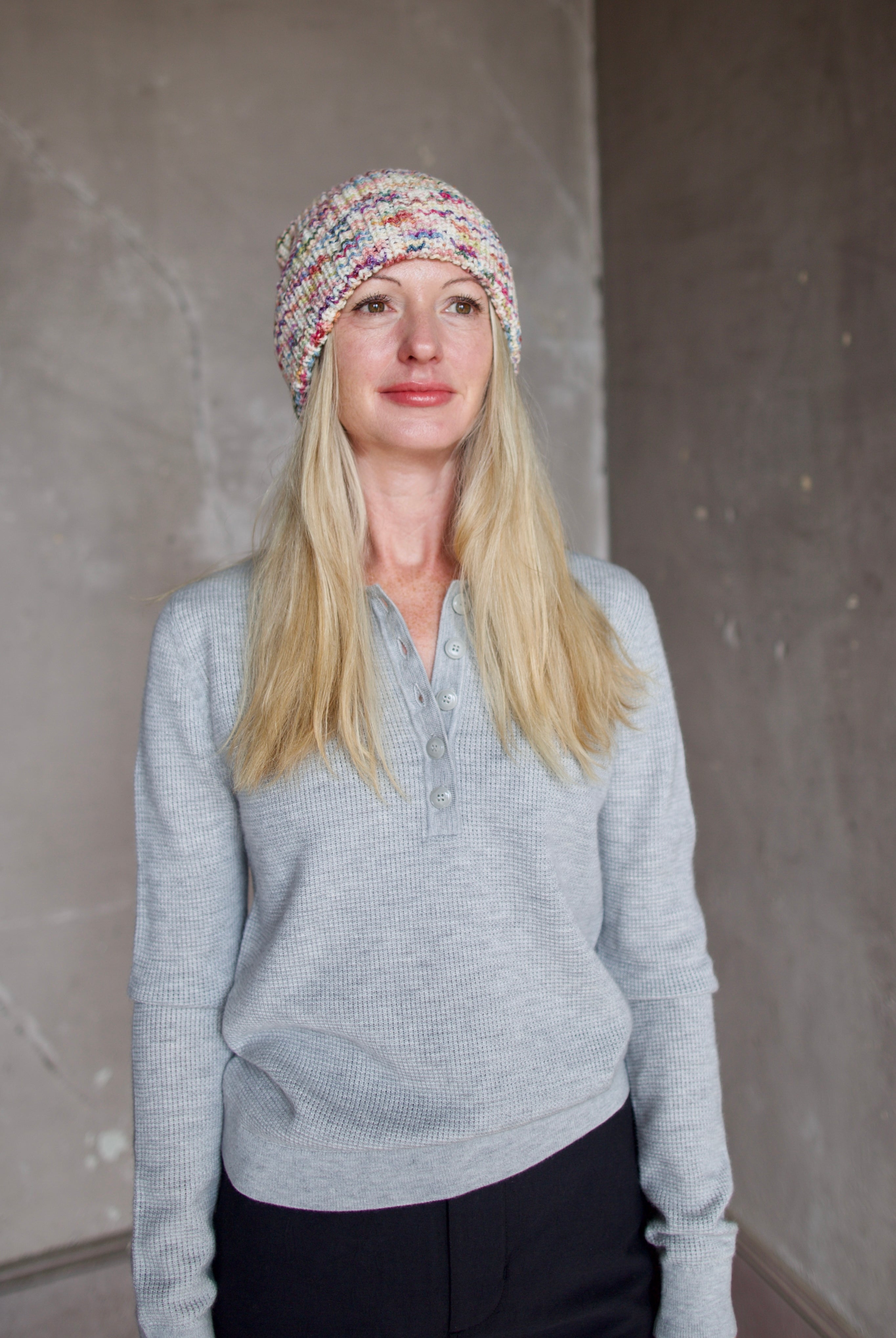 Model wearing Alix of Bohemia Yara Aurora Beanie. Knitted beanie is multicolored with cuff detail.