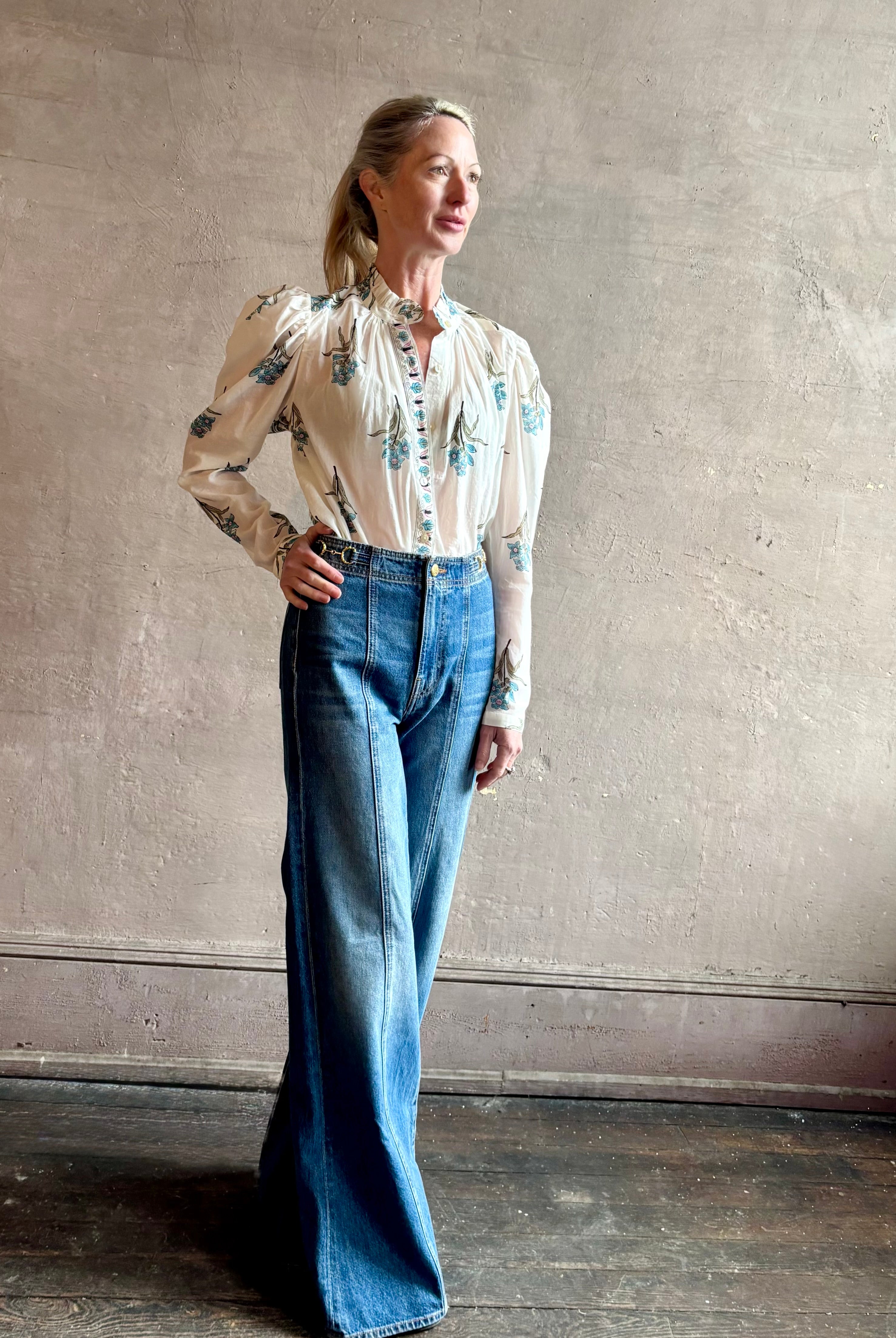 Image of woman wearing ALIX OF BOHEMIA Artemis Sky Mist Flower Shirt with long sleeves and delicate ruffle at neckline