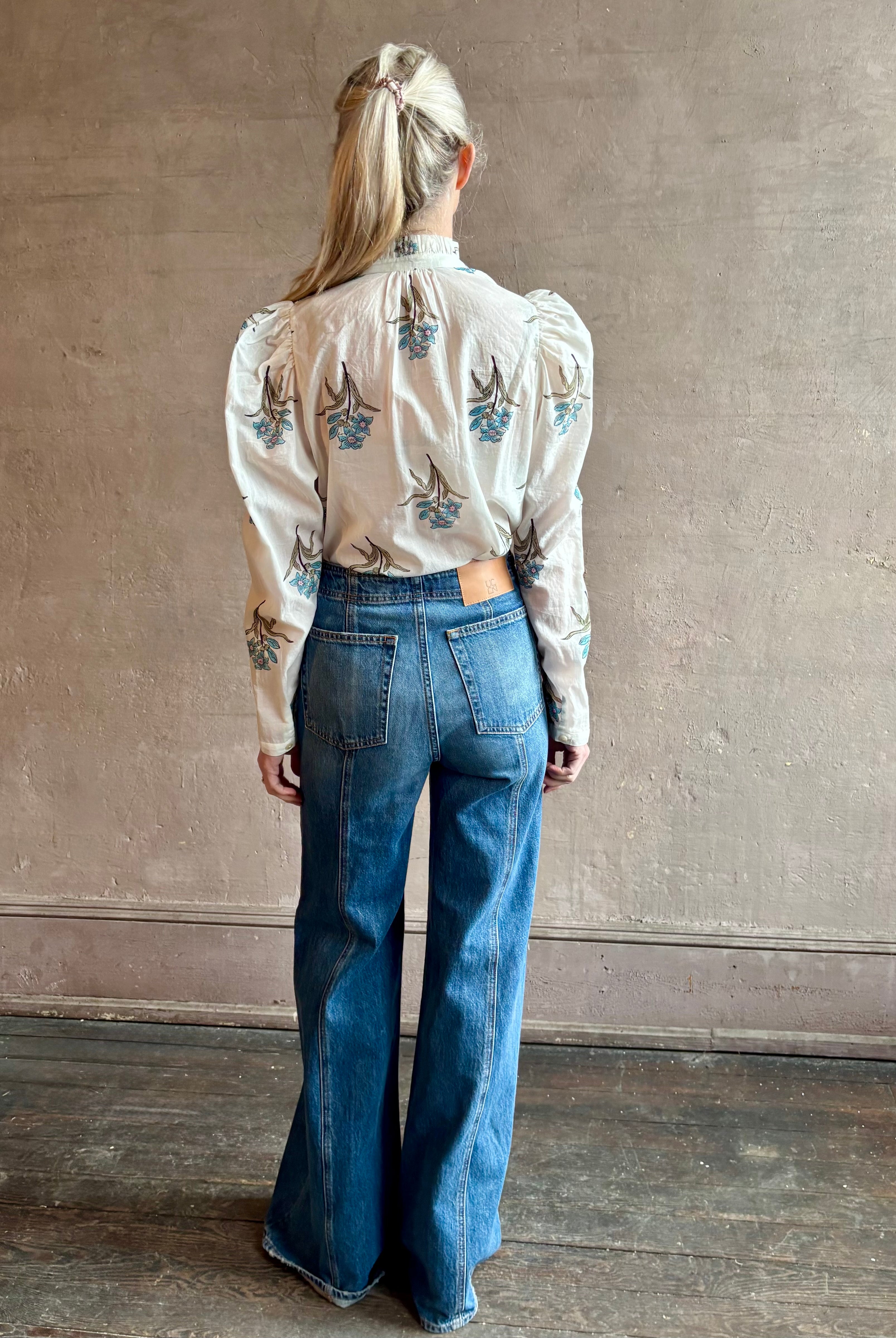 Image of woman wearing ALIX OF BOHEMIA Artemis Sky Mist Flower Shirt with Off-White background and aqua and pink floral print