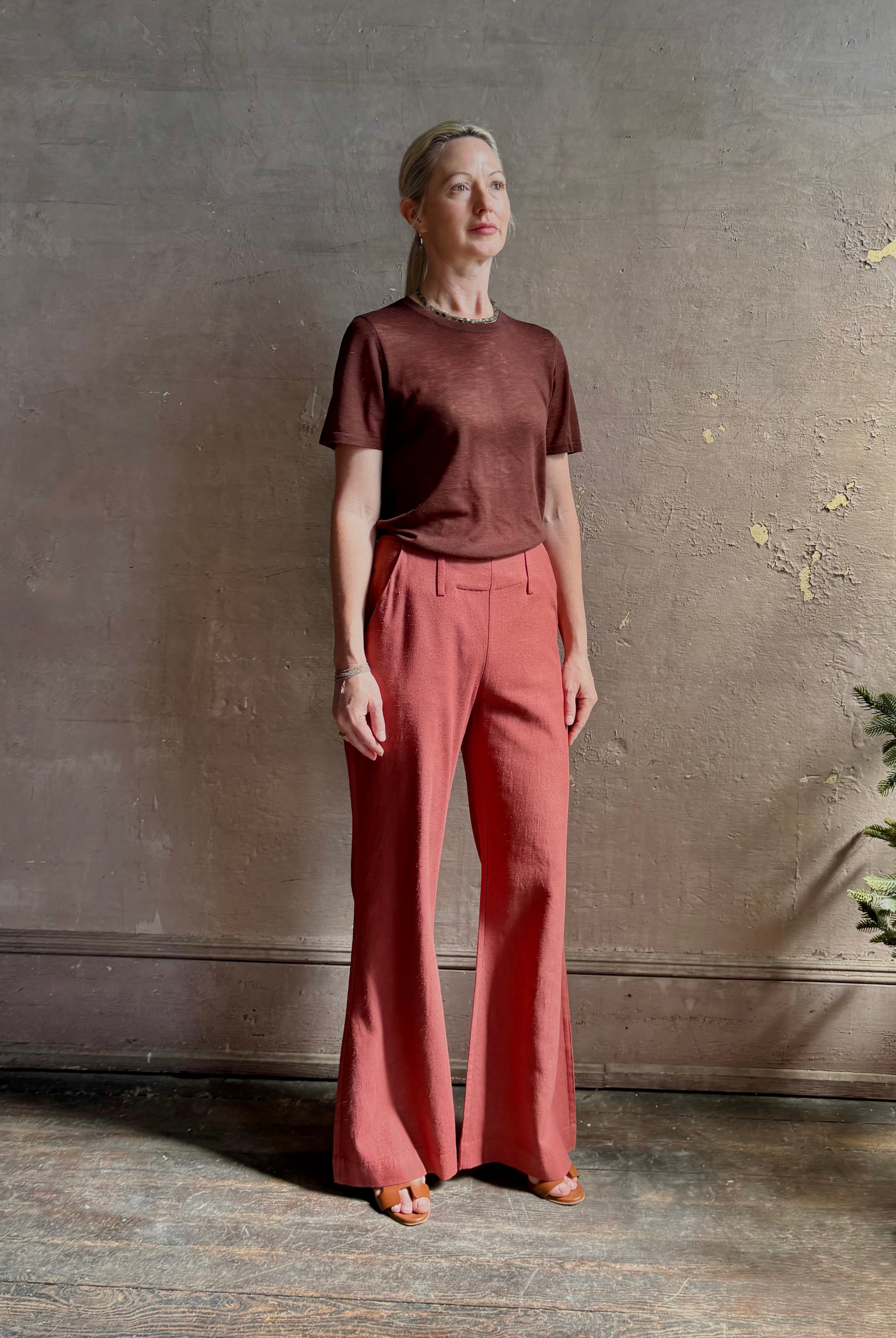 Woman wearing sophisticated ALIX OF BOHEMIA Charlie Red Ochre Silk mid-rise Pant with front and back pockets, belt loops, flat front and full length straight leg