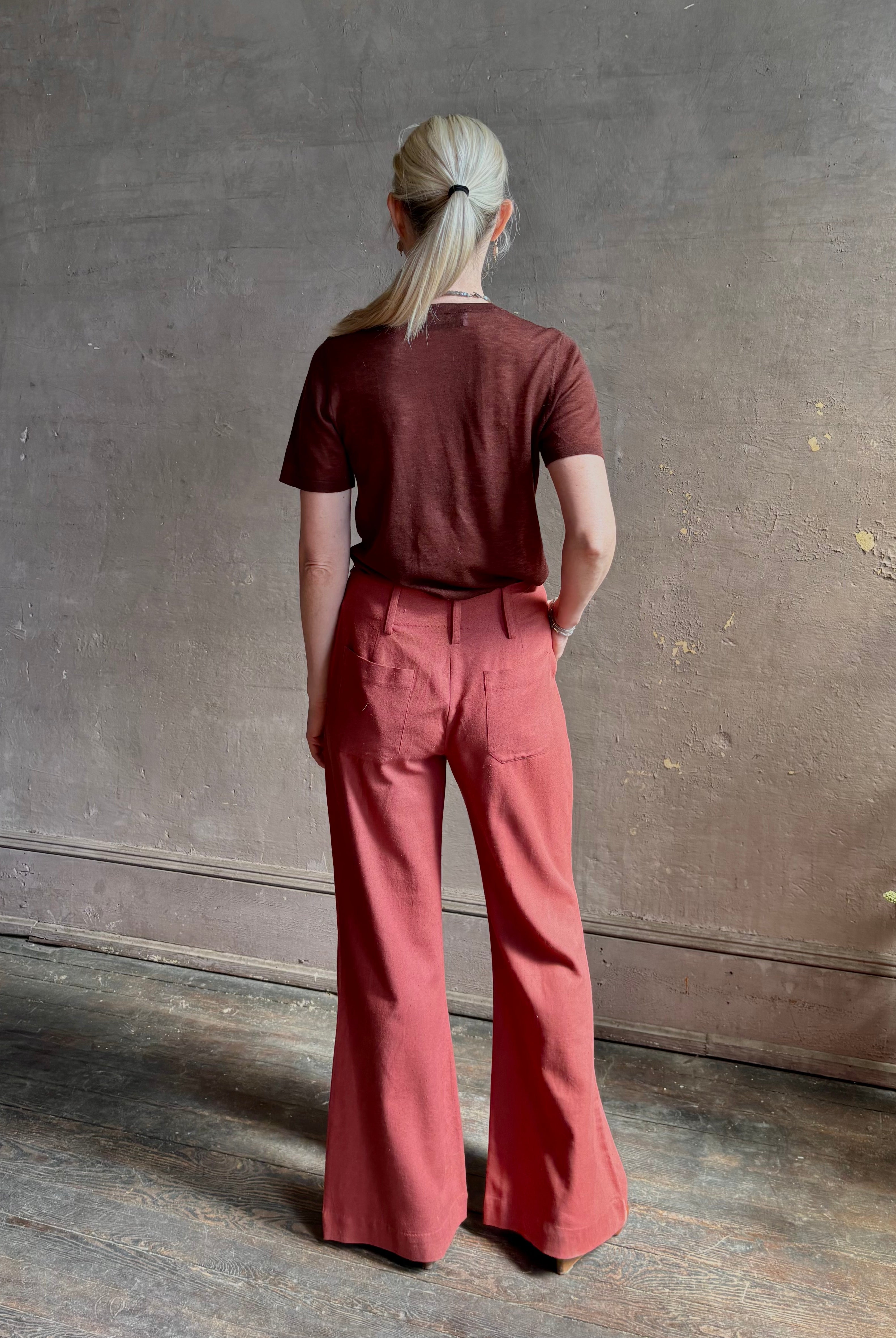 Woman wearing sophisticated ALIX OF BOHEMIA Charlie Red Ochre Silk mid-rise Pant with front and back pockets, belt loops, flat front and full length straight leg