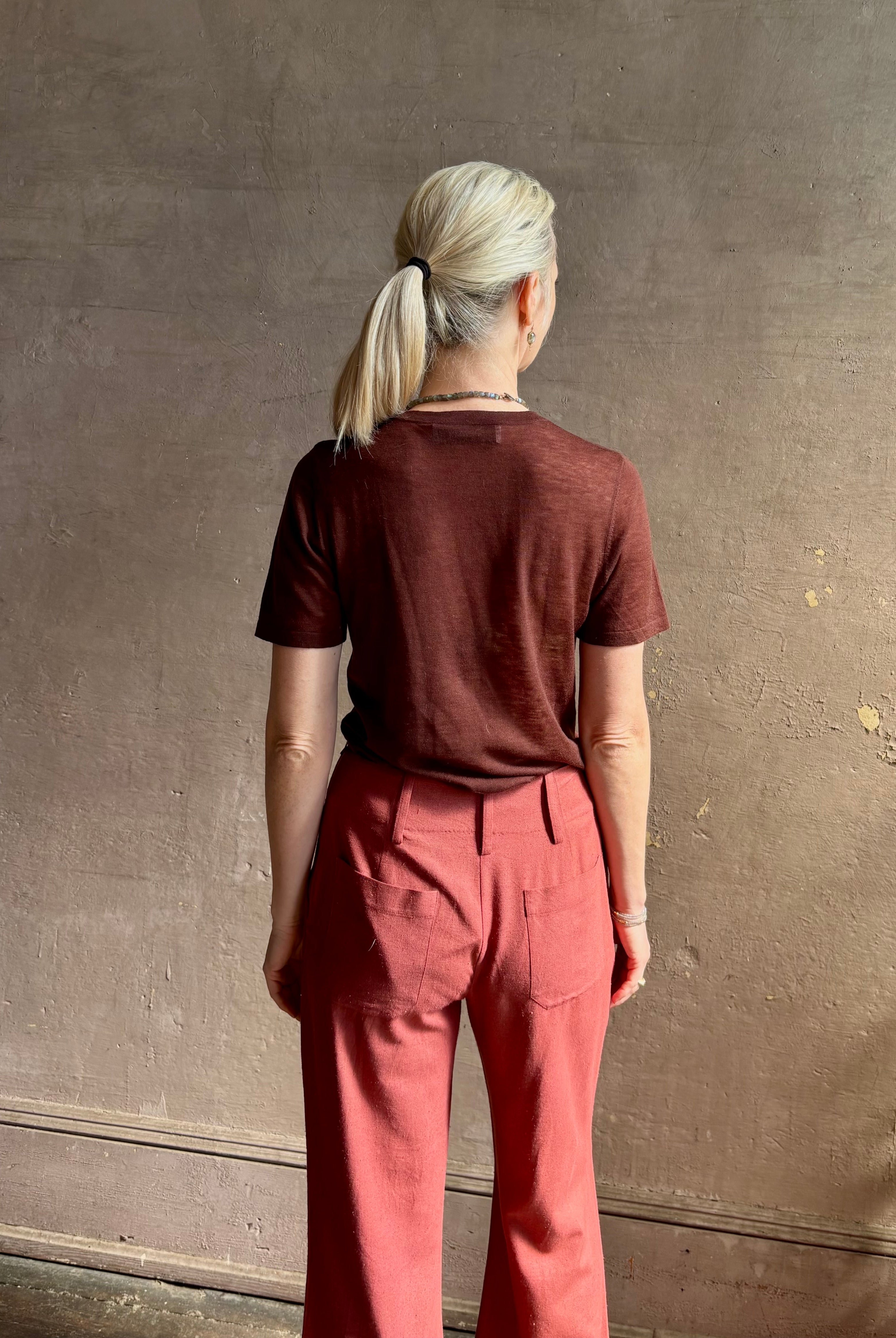 Woman wearing sophisticated ALIX OF BOHEMIA Charlie Red Ochre Silk mid-rise Pant with front and back pockets, belt loops, flat front and full length straight leg