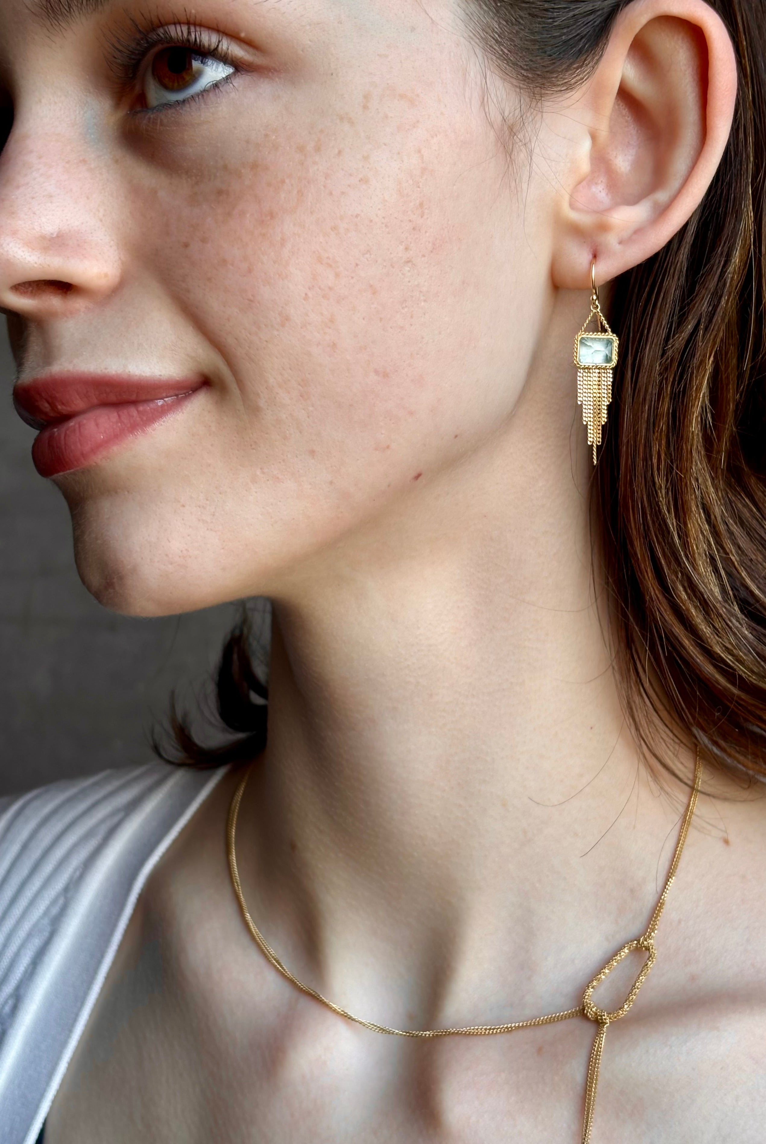 Woman wearing handmade New York designer Amali rectangular aquamarine and 18k yellow gold drop earrings with elegant gold fringe dangle embellishments