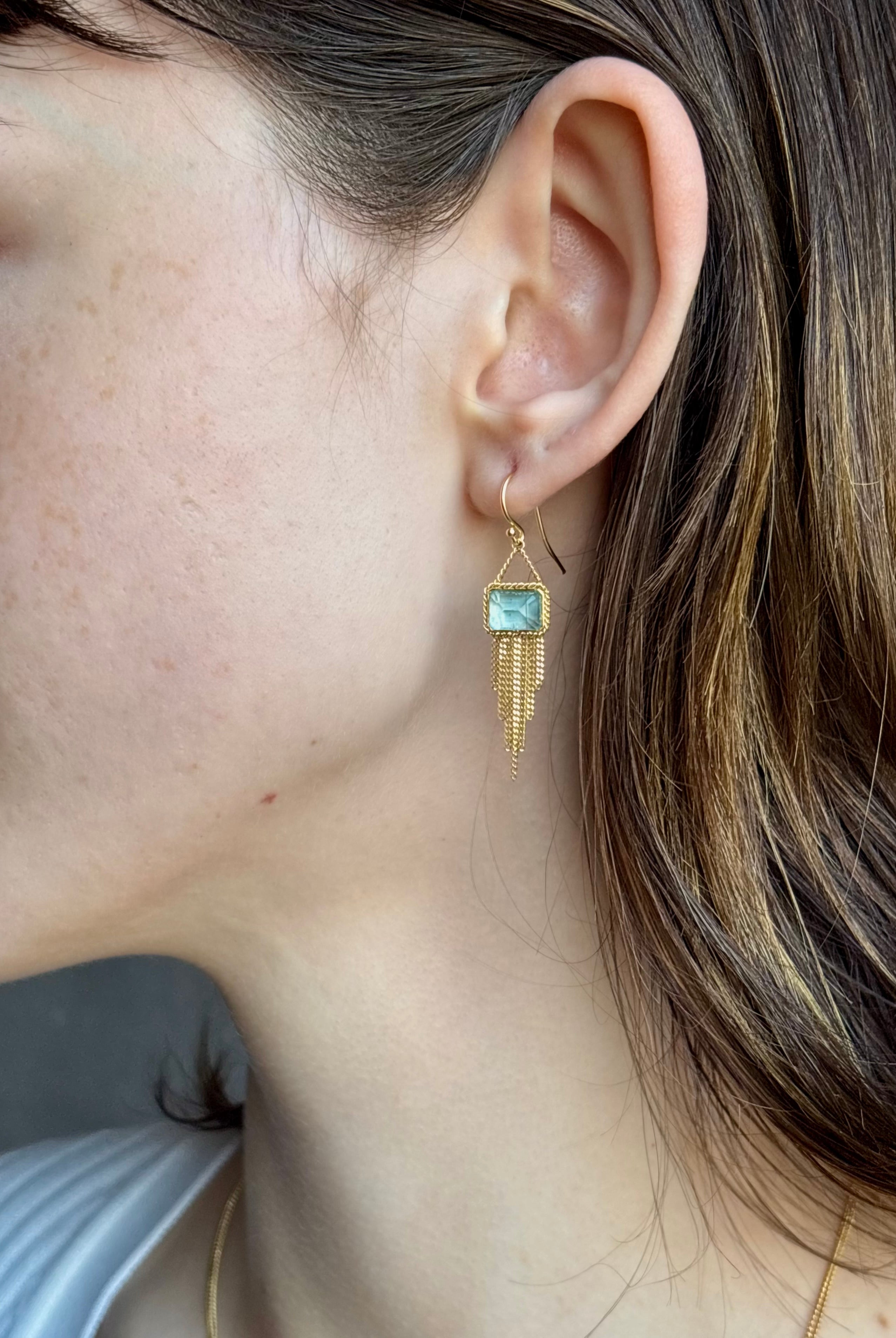 Woman wearing handmade New York designer Amali rectangular aquamarine and 18k yellow gold drop earrings with elegant gold fringe dangle embellishments